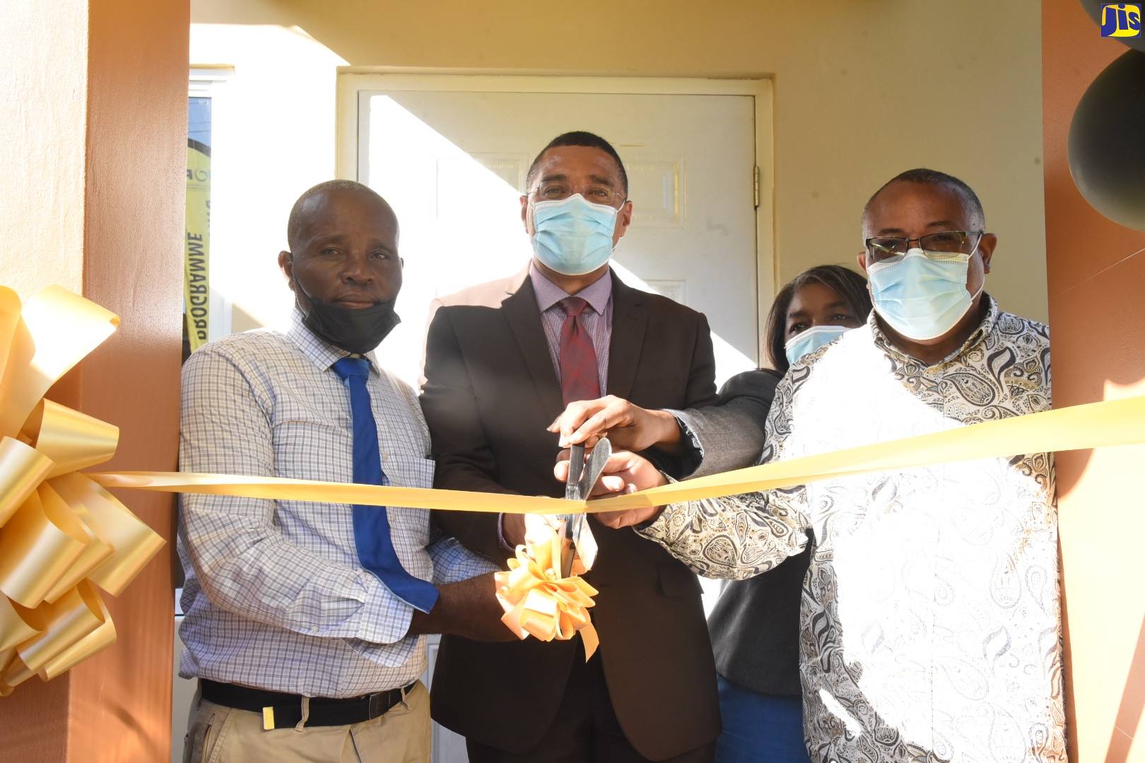 Prime Minister, the Most Hon. Andrew Holness (second left), cuts the ribbon to hand over a newly built two-bedroom house to Collington Graham (left) in Seaview Gardens, St. Andrew, recently. Joining them are Chair, New Social Housing Programme (NSHP), Judith Robb-Walters (second right); and Member of Parliament for St. Andrew Western, Anthony Hylton. The house was built under the NSHP.