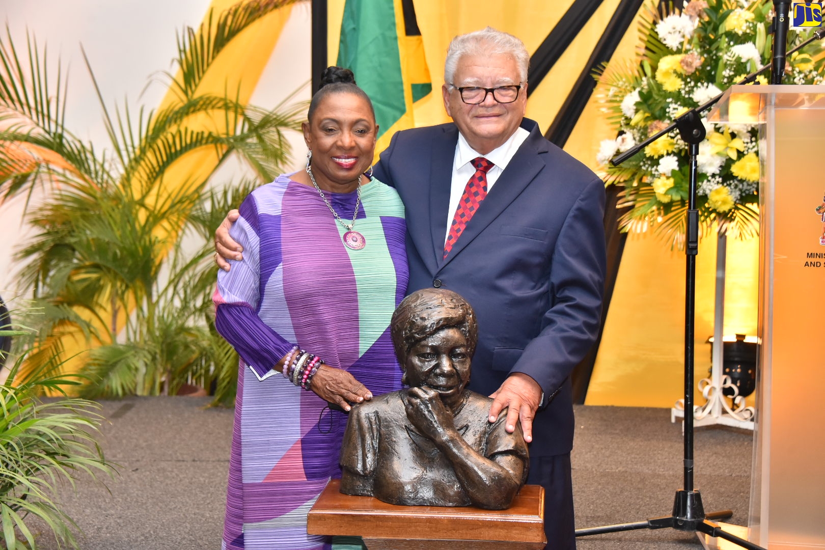 Minister of Culture, Gender, Entertainment and Sport, Hon. Olivia Grange (left), is hugged by Minister of Labour and Social Security, Hon. Karl Samuda, after she presented a maquette of one of Jamaica’s pioneer female labour rights activists, Agnes “Aggie” Bernard, during the Ministry of Labour and Social Security’s Labour Relations Awards Banquet, held at  the Jamaica Pegasus Hotel, recently. 