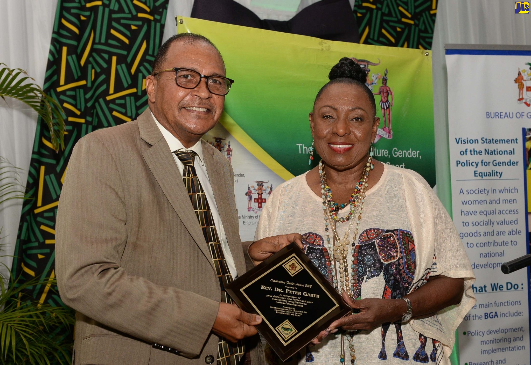 Minister of Culture, Gender, Entertainment and Sport, Hon. Olivia Grange (right) presents a plaque to the Ministry’s Outstanding Fathers Award nominee, Rev. Dr. Peter Garth at the ceremony held on Friday (June 17) at the Caymanas Golf Club, St. Catherine. It is one of several events organised by the Ministry’s Bureau of Gender Affairs to mark this year’s Father’s Day which will be celebrated on Sunday (June 19) under the theme, ‘Jamaica’s 60th: Fathering Yesterday, Today and Tomorrow’. The award aims to acknowledge and celebrate the vital role of fathers and father-figures within families and in the wider society and by extension, their contributions to nation building.