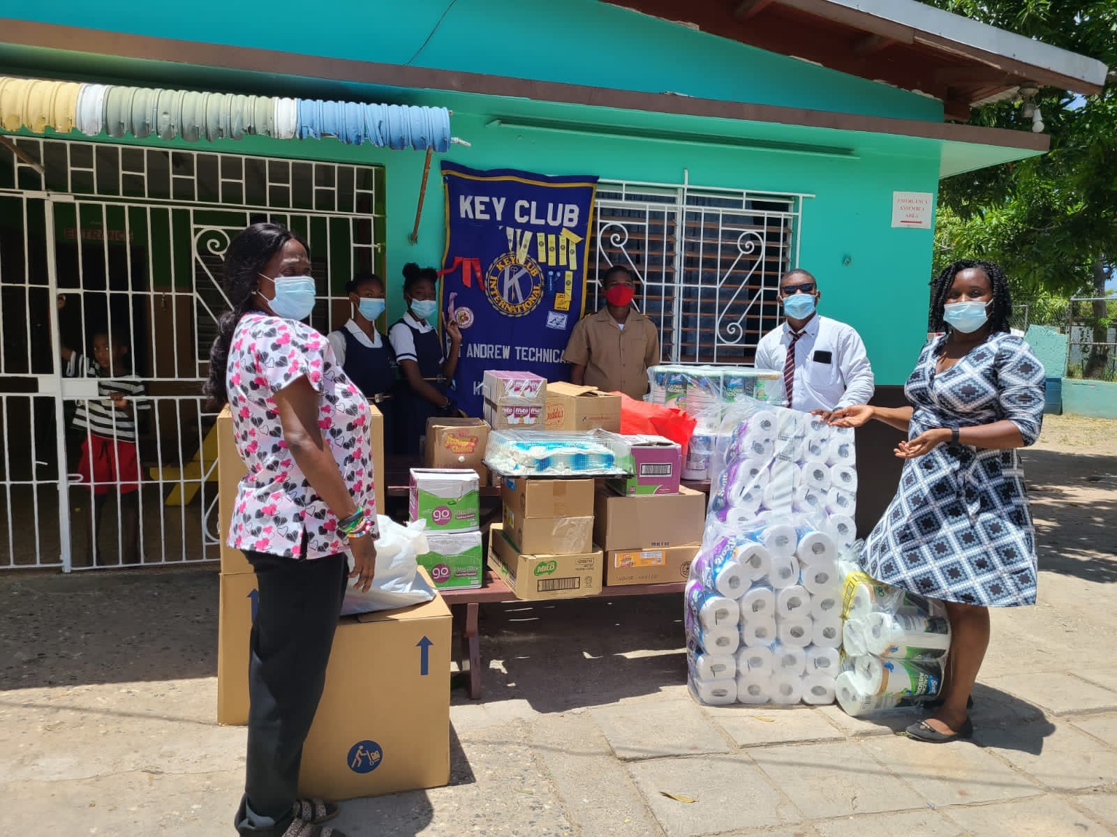 Members of the St. Andrew Technical High School Key Club, hand over packages to the Strathmore Gardens Children