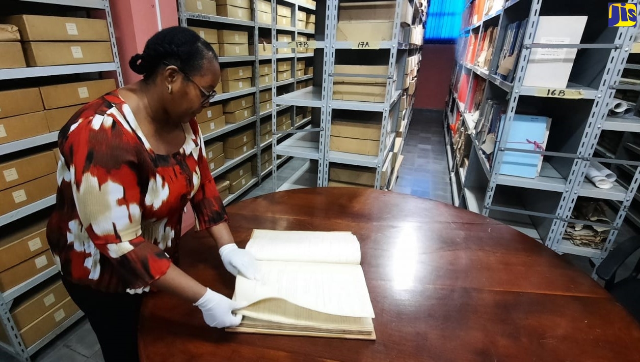 Senior Archivist, Jamaica Archives and Records Department (JARD), Racquel Innerarity, examines one of the many records that make up the collection at JARD. 