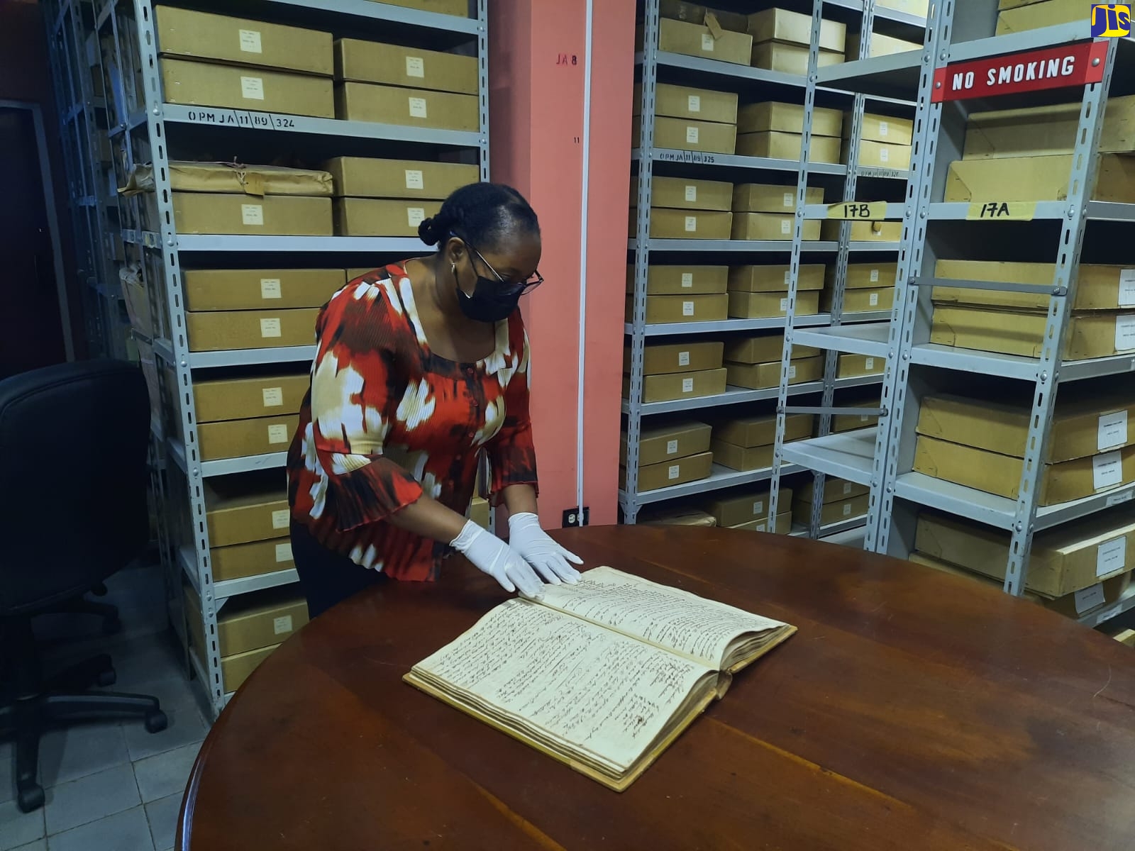 Senior Archivist at the Jamaica Archives and Records Department, Racquel Innerarity, carefully checks the Minutes of the Education Board 1833-1859 – the Jamaica Free School, just one of the many records archived at the Department. Mrs. Innerarity says all are welcome to access records because they belong to all Jamaicans.