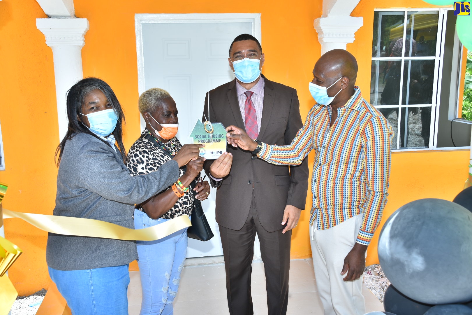 Prime Minister, the Most Hon. Andrew Holness (second right), presents the keys for a three-bedroom house to Ewarton St. Catherine, resident,  Ivy Smith (second left). Others (from left) are Chairperson, Oversight Committee, New Social Housing Programme (NSHP), Judith Robb Walters, and Member of Parliament for St. Catherine North West, Hugh Graham.