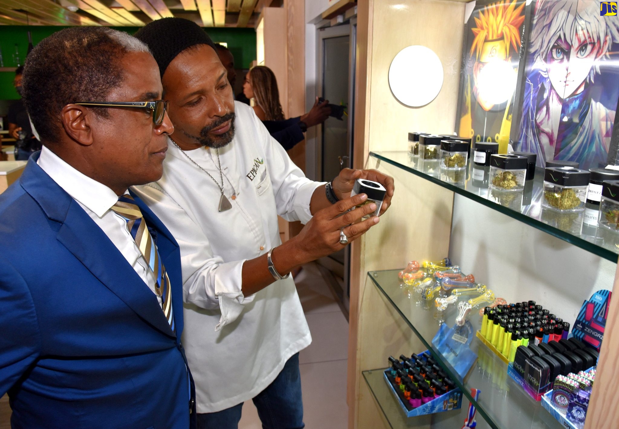 State Minister in the Ministry of Industry, Investment and Commerce, Dr. the Hon. Norman Dunn (left), looks on as President of Epican, Dwayne McKenzie, shows him one of the 16 rare cannabis strains being introduced by Epican to the local market, during the launch on June 15, at Market Place on Constant Spring Road.