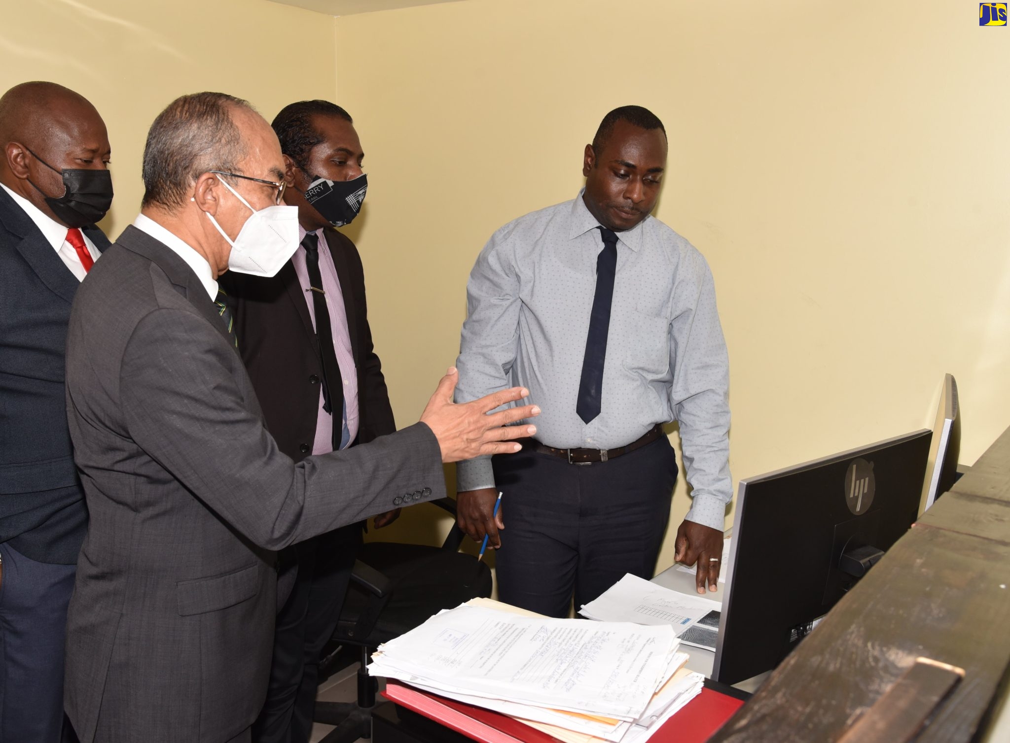 Minister of National Security, Hon Dr. Horace Chang (left), makes an observation of the new the Multi-Biometric Identification System, during his visit to the Jamaica Constabulary Force’s Criminal Records Office on Thursday (June 9). Looking on are (from left) Head of the JCF Technology Branch, Assistant Commissioner of Police, Leonardo Brown; Detective Sergeant Kirkland Tomlinson, and Detective Corporal Logan Thomas.  