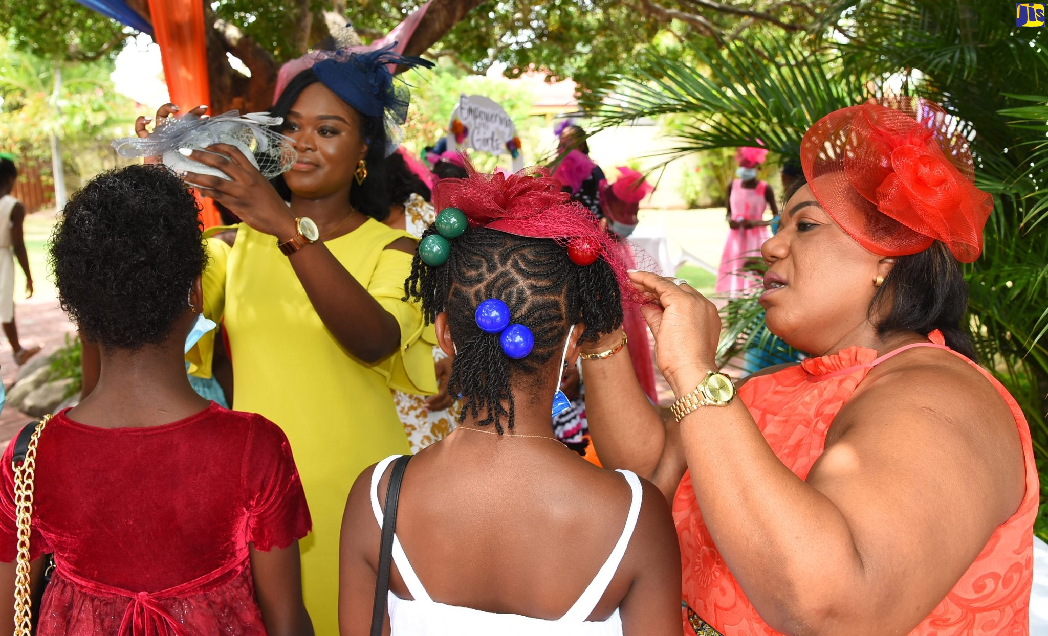 Chief Education Officer, Child Protection and Family Services Agency (CPFSA), Rosalee Gage-Grey (right) and Children’s Officer, CPFSA, Sassah-Gaye McPherson adjust fascinators being worn by young wards of the State, during the 