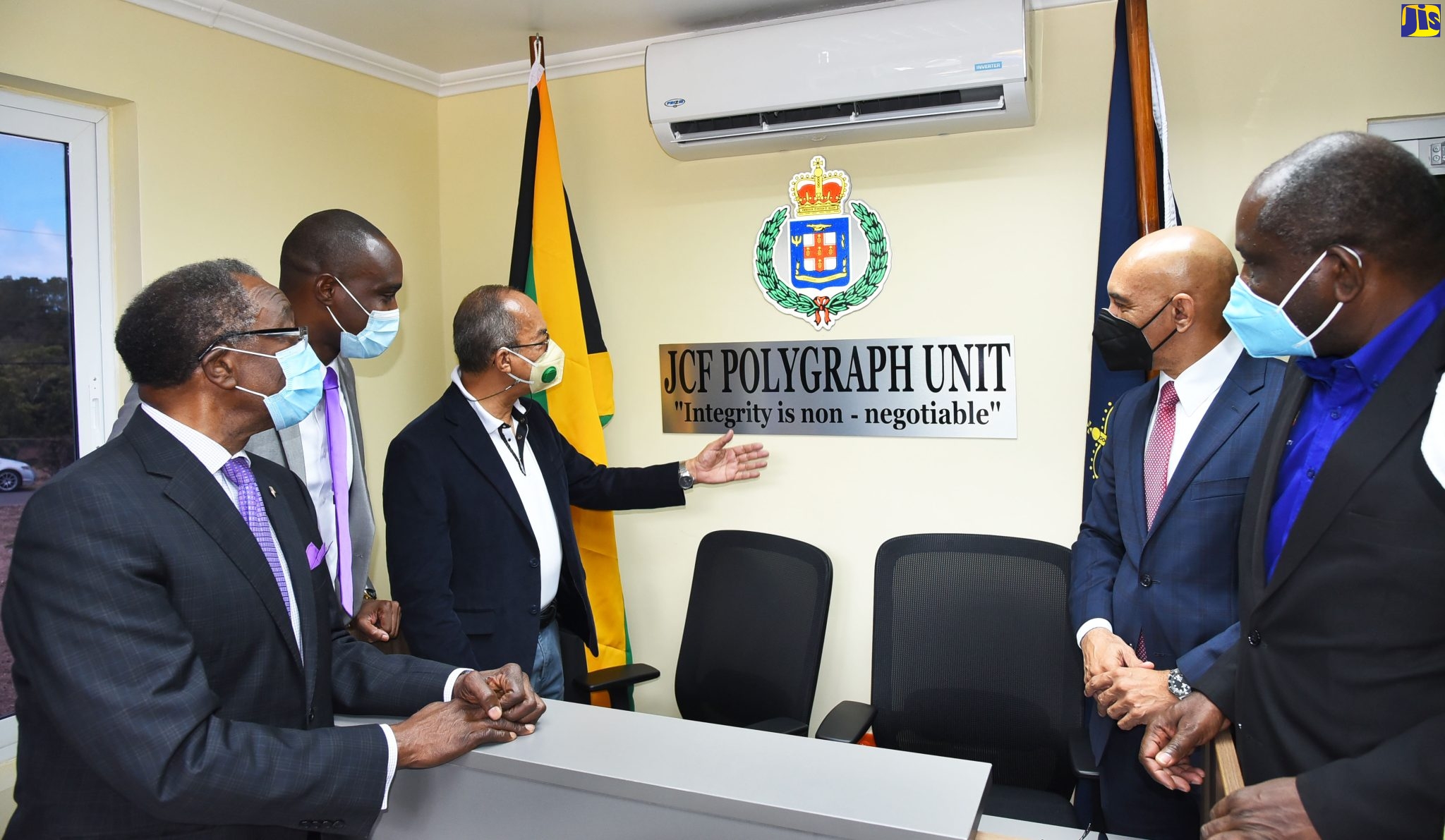 National Security Minister, the Hon. Dr. Horace Chang (third left), points to the sign of the newly refurbished Jamaica Constabulary Force (JCF) Polygraph Unit, during the official opening and handover of the unit on Friday (June 3) at the National Police College of Jamaica in Twickenham Park, St. Catherine. Looking on (from left) are: United States Ambassador to Jamaica, His Excellency Nick Perry; Head of the JCF Polygraph Unit, Assistant Superintendent of Police (ASP), Dwight Sommers; Commissioner of Police, Major General Antony Anderson; and Permanent Secretary in the Ministry of National Security, Courtney Williams. The unit was handed over by the International Narcotics and Law (INL) Enforcement Section of the Embassy of the United States, which partnered with the JCF on the initiative.