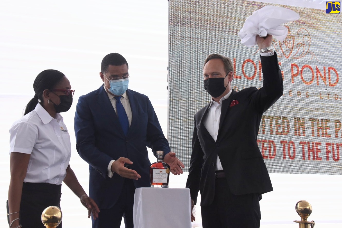 Prime Minister, the Most Hon. Andrew Holness (centre), admires Long Pond Distillery’s special edition Vale Royal Wedderburn (VRW), unveiled by Director of National Rums of Jamaica (NRJ),  Alexandre Gabriel (right), to celebrate the reopening of the distillery in Clark’s Town, Trelawny, on June 17. They are joined by Chief Executive Officer of NRJ, Martha Miller.