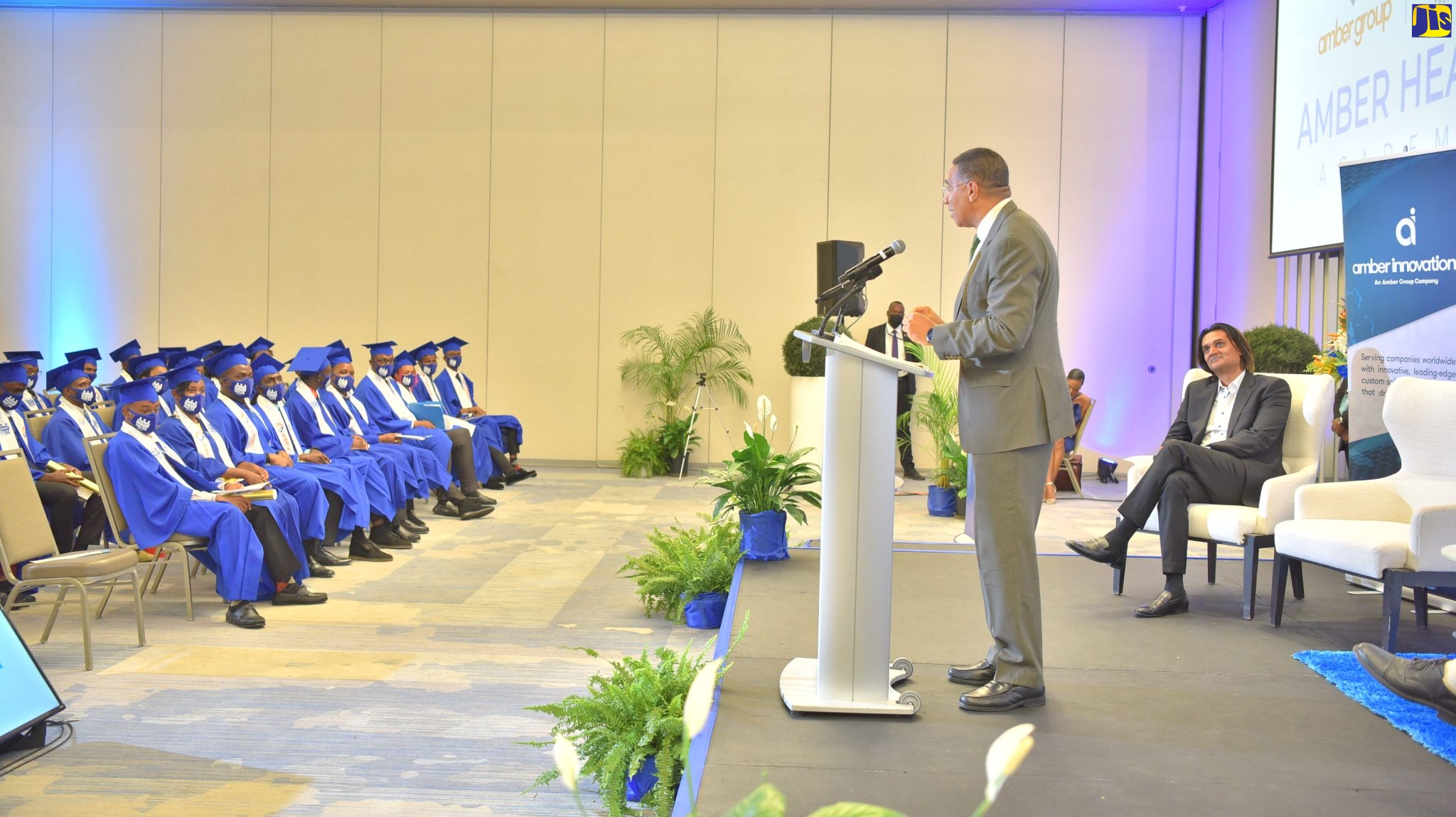 Prime Minister, the Most Hon. Andrew Holness (at podium), addresses the graduation ceremony for the first batch of coders from the Amber HEART Academy, at the AC Hotel by Marriot Kingston, recently. At right is Founder and Chief Executive Officer of the Amber Group, Dushyant Savadia.