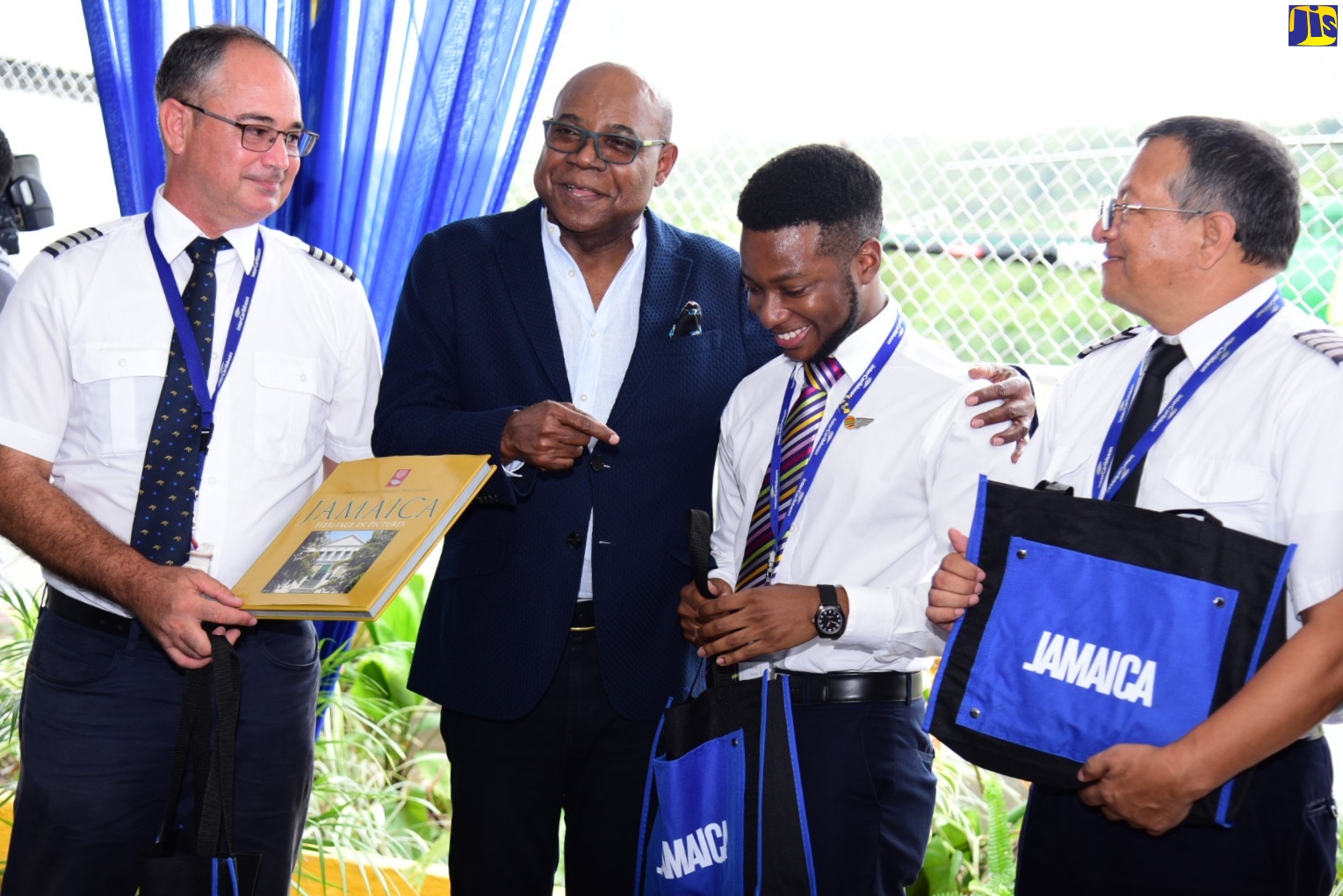 Minister of Tourism, Hon. Edmund Bartlett (second from left), presents gifts to the InterCaribbean Airways flight crew, who brought the first scheduled international flight into the Ian Fleming International Airport in Boscobel, St Mary, on Thursday (June 16). From left is Captain Ciro Chacon; flight attendant, Joshua Christiano Small; and Pilot, Peter Stanley.