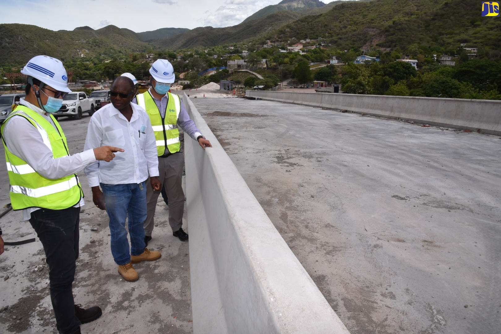 Minister without Portfolio in the Ministry of Economic Growth and Job Creation, Hon. Everald Warmington (centre), listens to Commercial Manager at the China Harbour Engineering Company (left),  Li Fei, during a tour of the Southern Coastal Highway Improvement Project on Thursday, June 2. At right is Project Manager, Xu Daan.