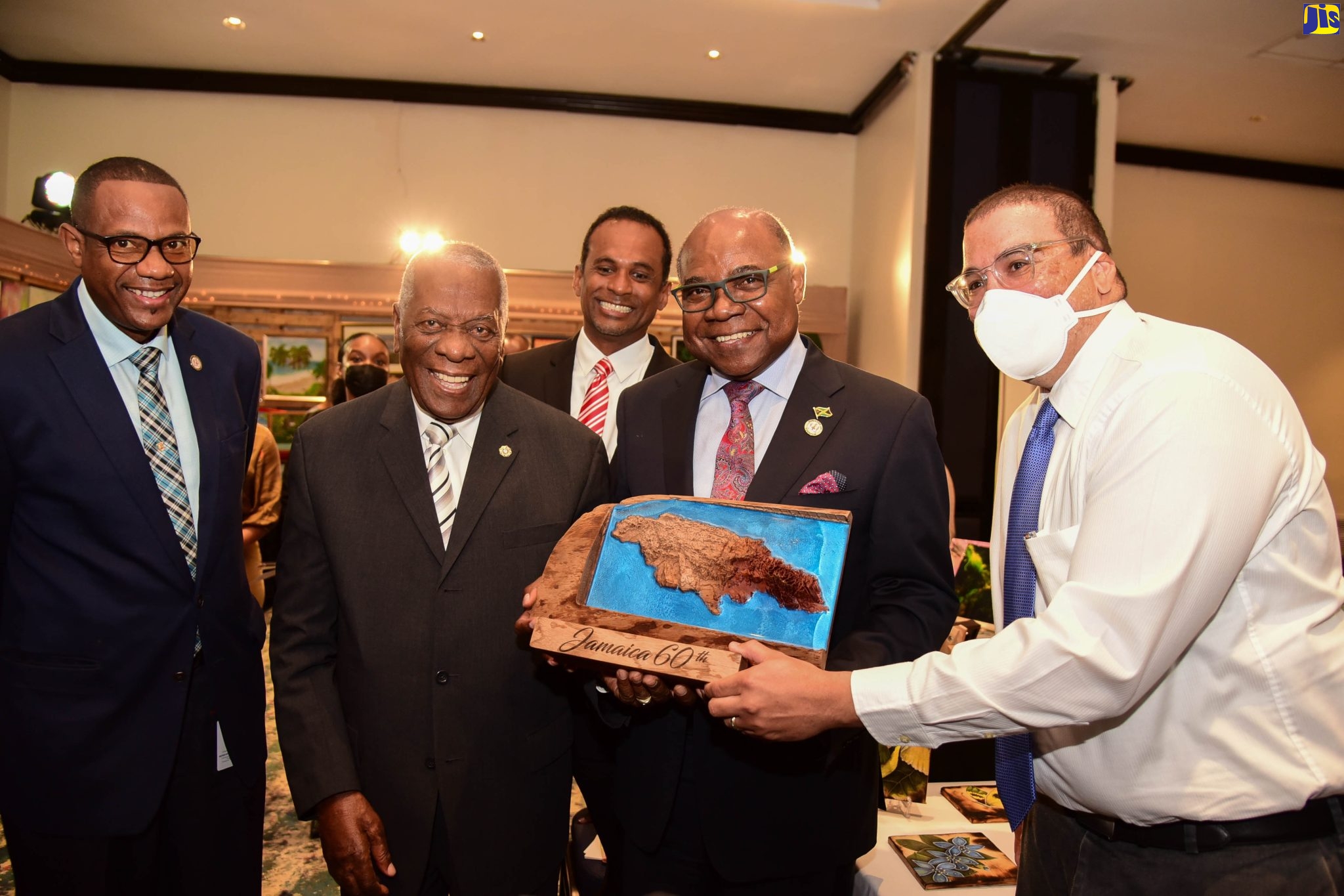 Minister of Tourism, Hon. Edmund Bartlett (second right), is presented with a souvenir by Founder/Managing Director of Wood Man 876, Dameion Thompson (right), during the eighth ‘Christmas in July’ trade show, at the Jamaica Pegasus Hotel in New Kingston, on Tuesday (July 12). Others (from left) are: Chief Technical Director in the Tourism Ministry, David Dobson; Tourism Enhancement Fund (TEF) Chairman, Godfrey Dyer; and TEF Executive Director, Dr. Carey Wallace.