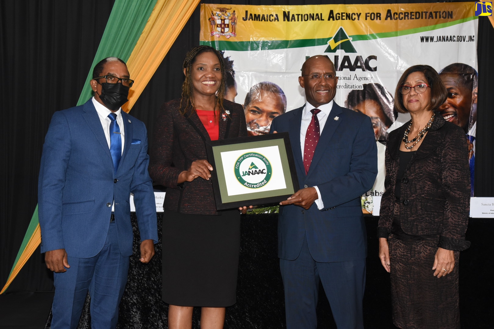 Minister of Industry, Investment and Commerce, Senator the Hon. Aubyn Hill (second right), presents Chief Executive Officer, Jamaica National Accreditation Agency (JANAAC), Sharonmae Shirley (second left), with the United States Food and Drug Administration (FDA) Accredited Third-Party Certification Programme certificate, during a semi-virtual ceremony at The Jamaica Pegasus hotel in New Kingston on Tuesday (July 19). Sharing the moment (from left) are State Minister in the Ministry, Dr. the Hon. Norman Dunn and Permanent Secretary, Sancia Bennett Templer. JANAAC is an agency of the Ministry.