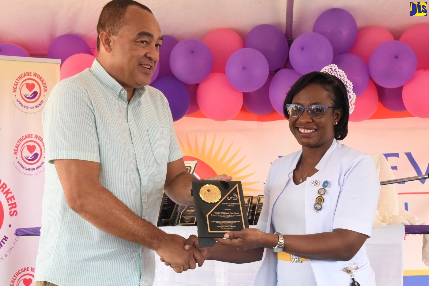 Health and Wellness Minister, Dr. the Hon. Christopher Tufton (left), presents Deputy Director,  Nursing Services (Acting),  Bellevue Hospital, Trecia Williams Morrison, with the ‘Staff Excellence Award’ in recognition of her outstanding contribution, during the institution’s Staff Wellness Day and Awards ceremony on Wednesday (July 20). The event, held at the hospital’s Windward Road address in St. Andrew, formed part of activities for National Healthcare Workers Appreciation Month.


