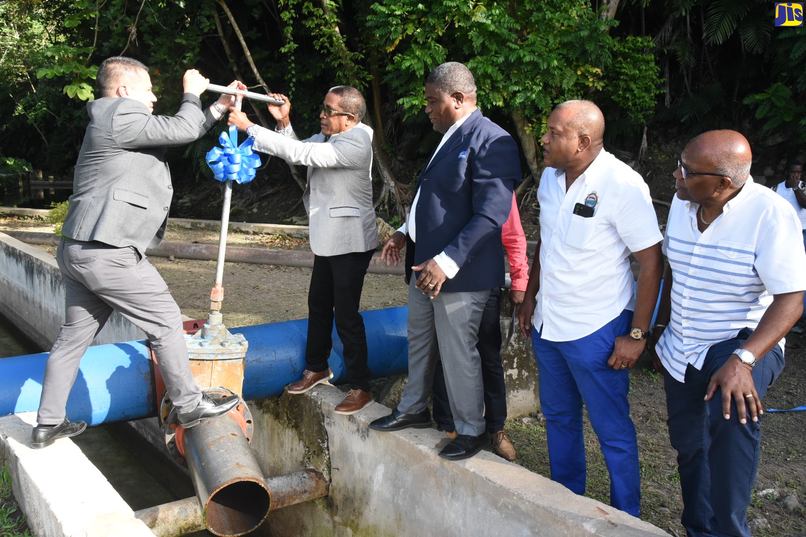 Minister without Portfolio in the Ministry of Economic Growth and Job Creation, Senator the Hon. Matthew Samuda (left), is assisted by Member of Parliament (MP) for St. Mary South East, Dr. the Hon. Norman Dunn (second left), to turn on the improved Iterboreale well pump in St. Mary on July 21. Observing (from third left) are: National Water Commission’s (NWC) Regional Manager, Richard Williams; His Worship the Mayor of Port Maria, Richard Creary and MP for St. Mary Central, Dr. Morais Guy.