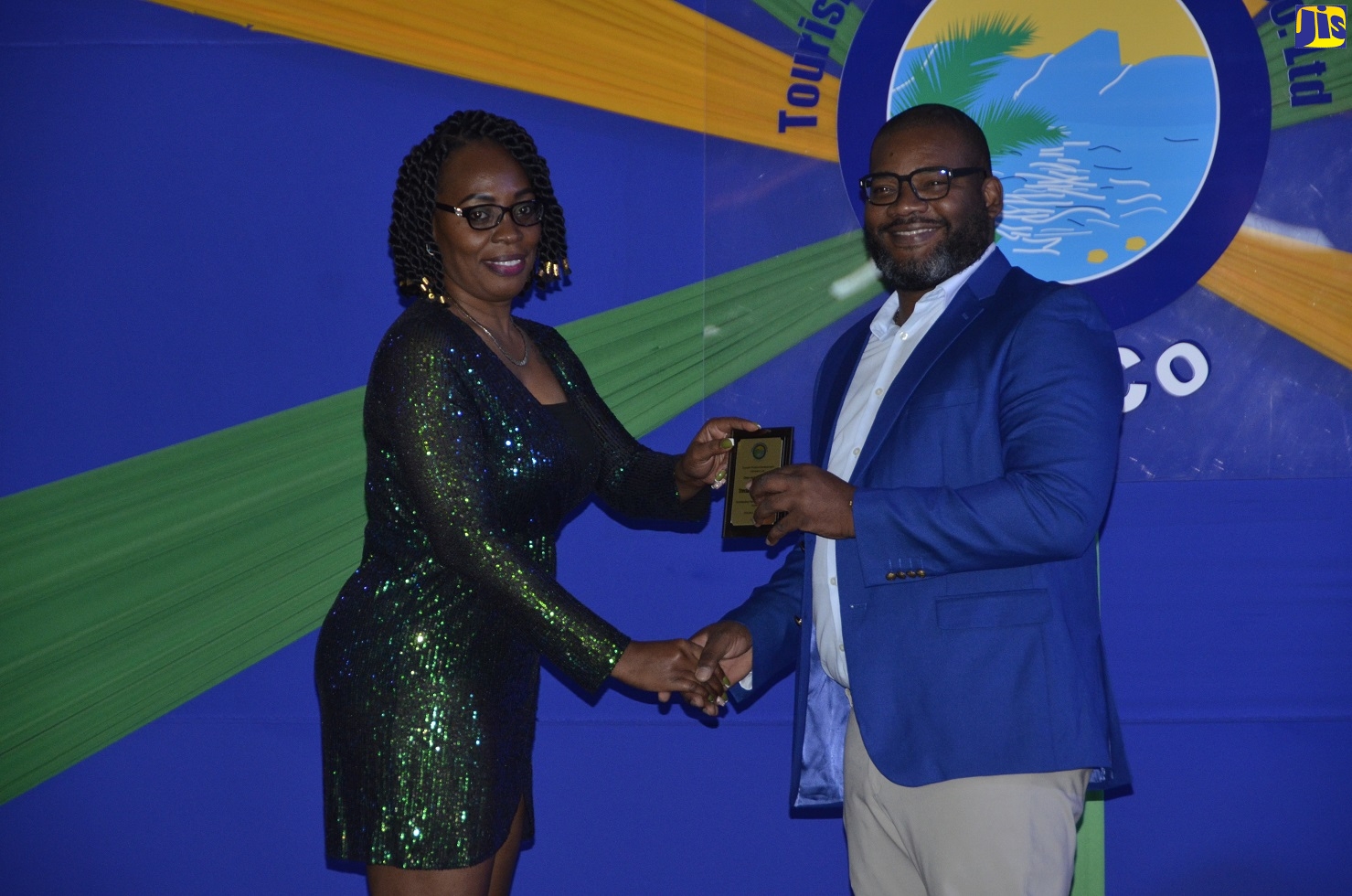 Executive Director of the Tourism Product Development Company Limited (TPDCo) Wade Mars (right), presents the overachiever spotlight award to Trecia Harris-Smiley (left) from the Ocho Rios Region at the company’s staff recognition awards ceremony held at the Montego Bay Convention Centre, Rose Hall, St James on Thursday (July 7).