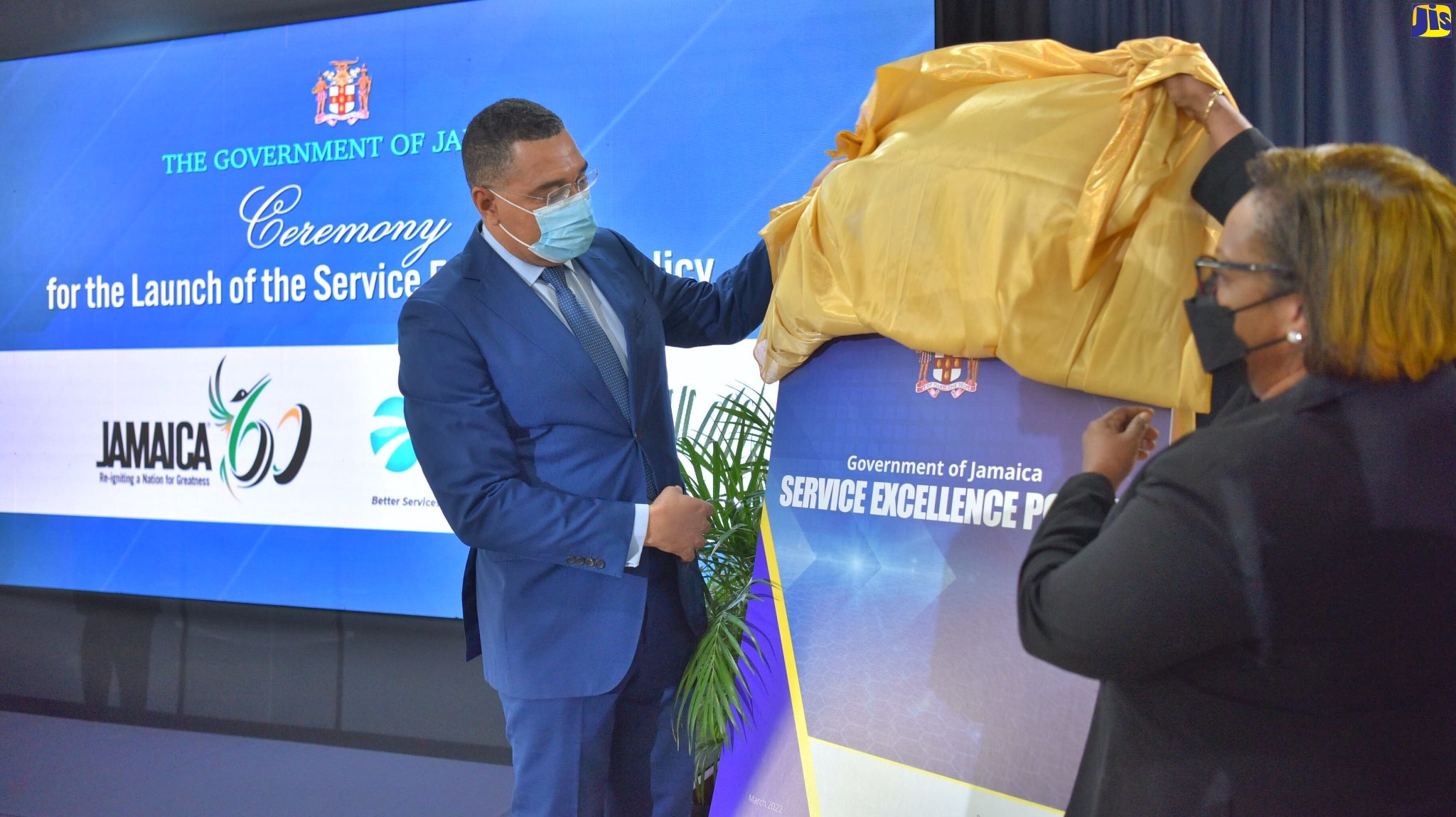 Prime Minister the Most Hon. Andrew Holness (left) and Chief Technical Director, Office of the Cabinet, Marjorie Johnson unveil the Service Excellence Policy during the official launch at the Office of the Prime Minister in St. Andrew on July 13.