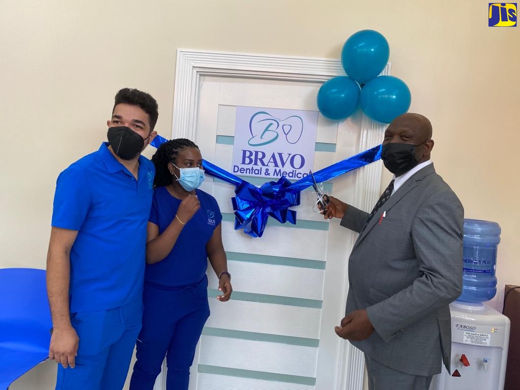 Mayor of St. Ann’s Bay, Councillor Sydney Stewart (right), cuts the ribbon to officially open the Bravo Dental and Medical Centre in St. Ann’s Bay, St. Ann recently.  He is joined by husband-and wife-team, Drs. Alexandre Young (left) and Ruth-Ann Leveridge-Young, who operate the facility.