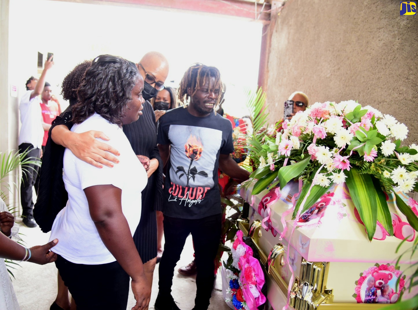 Minister of Education and Youth, Hon. Fayval Williams (second from left), consoles grieving parents Micey Walters (left) and Owen Tomlinson, at the funeral for their children Kayla and Abigail Tomlinson, who perished in a fire that gutted their Haylesfield, Clarendon, home on March 24.  The funeral was held on Sunday (July 3) at the Race Course Seventh-day Adventist Church in the parish. 