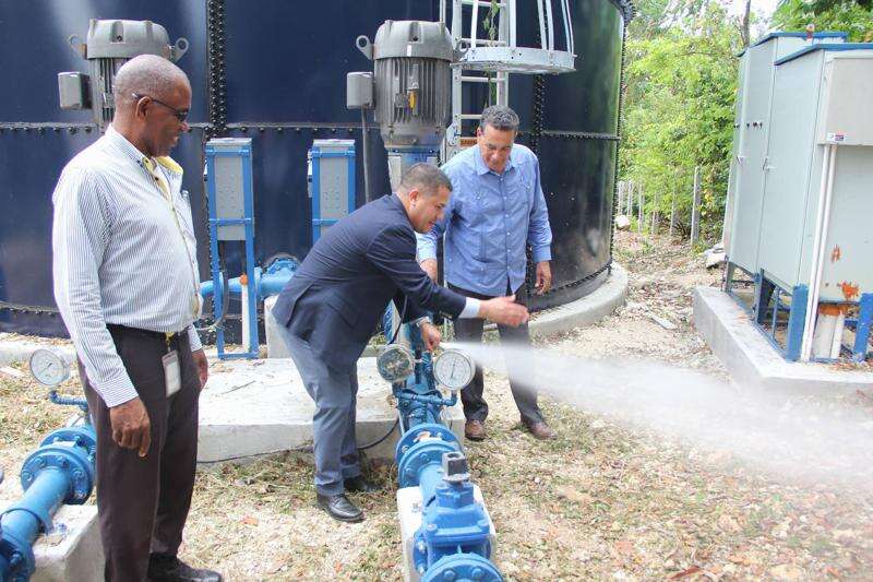 Minister without Portfolio in the Ministry of Economic Growth and Job Creation, Senator the Hon. Matthew Samuda (centre), tests the water supply system following a tour of the Flower Hill Water Supply Improvement Project in St. James on July 20. Sharing the moment are National Water Commission (NWC) Production Manager for Trelawny and St. James, Fitzgerald Roach (left) and Minister of State in the Office of the Prime Minister, Hon. Homer Davis.