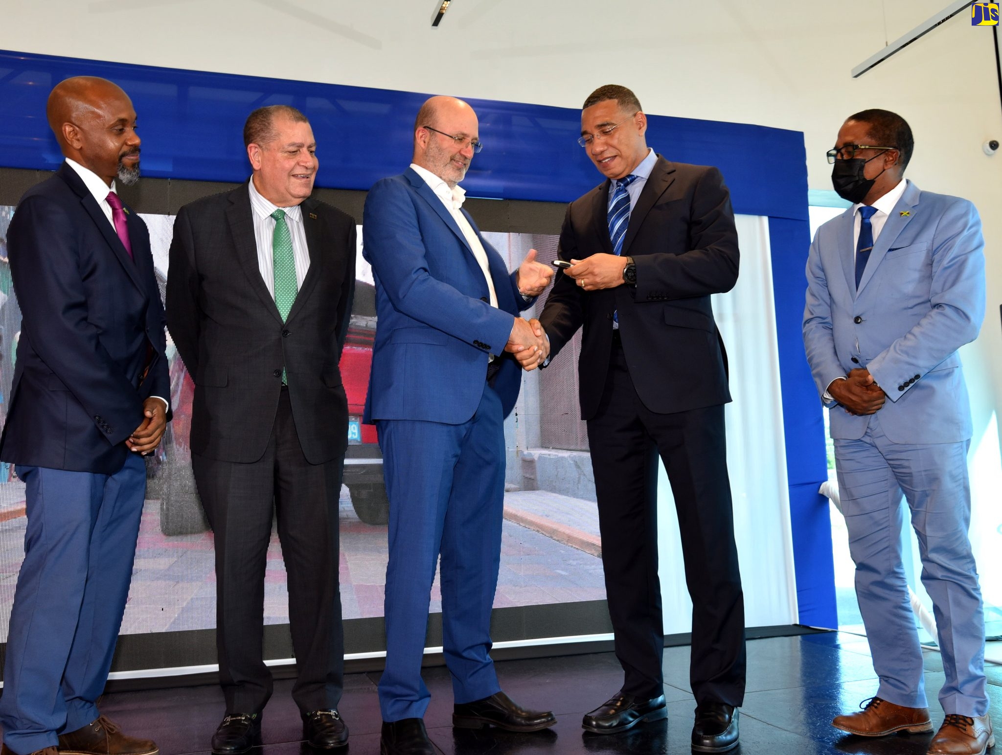 Prime Minister, the Most Hon. Andrew Holness (second right), accepts the keys for Build Your Dreams (BYD) electric vehicles, which will be distributed to five government ministries as part of the Government’s Electric Vehicle Trial Programme, from Managing Director of Stewart’s Automotive Group, Duncan Stewart (centre). Occasion was the launch of the programme at the Jaguar/Land Rover Showroom on Arthur Wint Drive in Kingston, on July 8. Observing  (from left) are Chief Technical Director, Ministry of Science, Energy and Technology, Brian Richardson; Minister of Transport and Mining, Hon. Audley Shaw, and State Minister in MIIC, Dr. the Hon. Norman Dunn. 