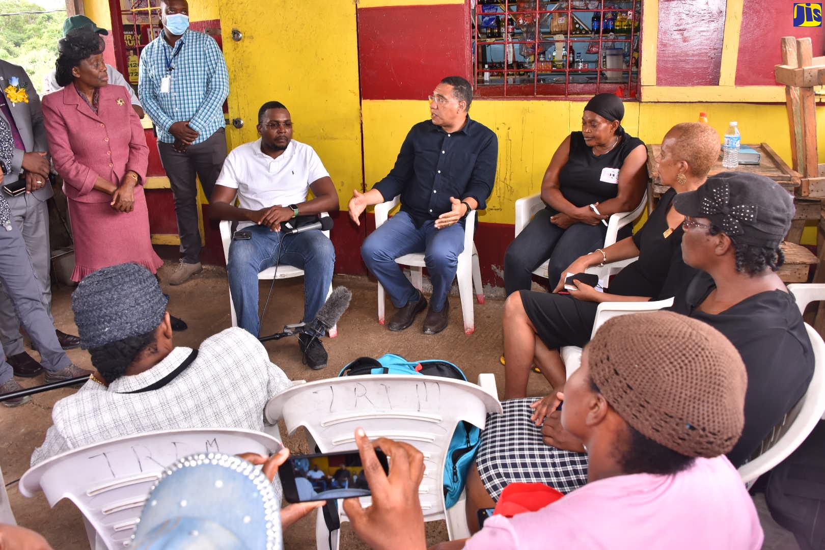 Prime Minister, the Most Hon. Andrew Holness (seated second left), makes a point during a visit on Friday (July 1) with Gwendolyn McKnight (seated third right), whose daughter and four grand-children were brutally murdered in Cocoa Piece, Clarendon on June 21. Joining him are  Member of Parliament for Clarendon North Central and Minister without Portfolio in the Office of the Prime Minister with Responsibility for Information, Hon. Robert Morgan (seated left); and Minister of Education and Youth, Hon. Fayval Williams (seated fourth left).