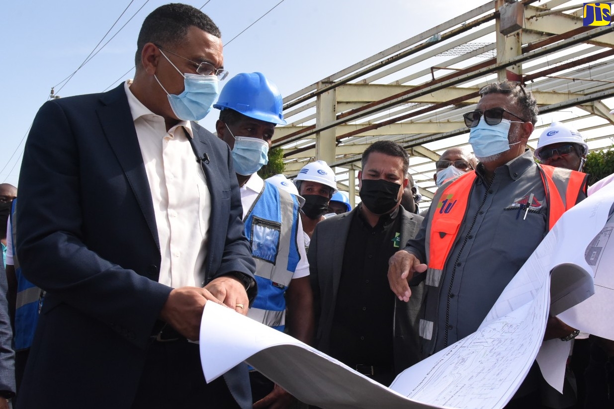 Prime Minister, the Most Hon. Andrew Holness (left), is shown construction plans for the Morant Bay Urban Centre, during a tour of the site on Thursday (July 14). With him are (from second left): Chairman of the Factories Corporation of Jamaica, Lyttleton Shirley; Minister without Portfolio in the Ministry of Economic Growth and Job Creation, Senator the Hon. Matthew Samuda and Architect, Bryan Morris.