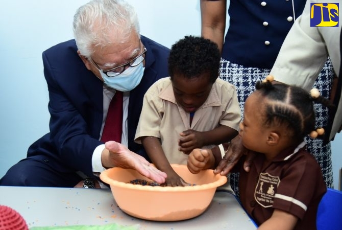 Minister of Labour and Social Security, Hon. Karl Samuda, interacts with students of the Early Stimulation Programme (ESP), Kaylee Ellis and Antoine Allen, at the opening of ESP’s sensation station in Kingston on May 31.
