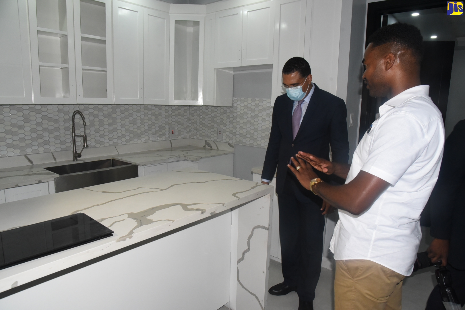 Prime Minister, the Most Hon. Andrew Holness (left), in discussion with Managing Director of Alfran Development Limited, Ricardo Foster, during the recent ribbon cutting ceremony for Genesis 28, the company’s first housing project, on Waterloo Road in St. Andrew.