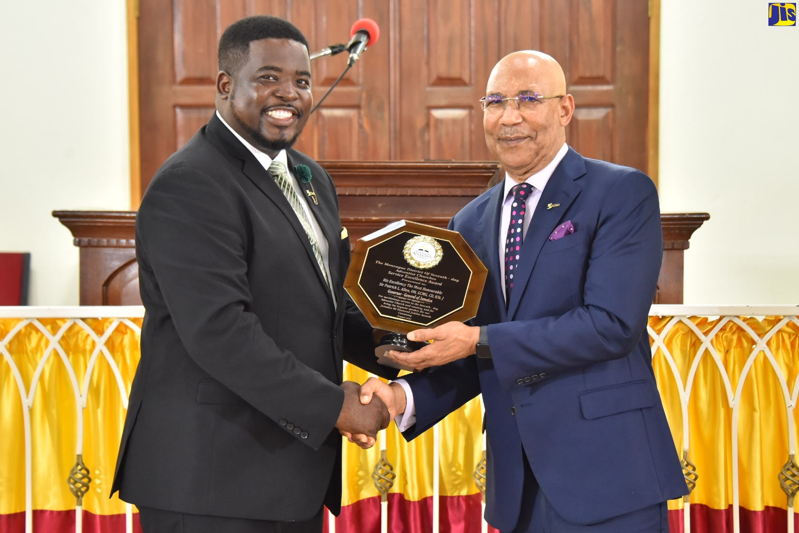 Pastor of the Moneague Seventh-day Adventist Church in St. Ann, Jermaine Johnson (left), presents Governor General, His Excellency, the Most Hon. Sir Patrick Allen, with an award for meritorious service to the Seventh-day Adventist Church and the development of Jamaica during the Service of Excellence and Recognition awards ceremony at the church on Sunday (August 14). The function was hosted by the Moneague District of Seventh-day Adventist Churches to mark Jamaica’s 60th year of Independence.