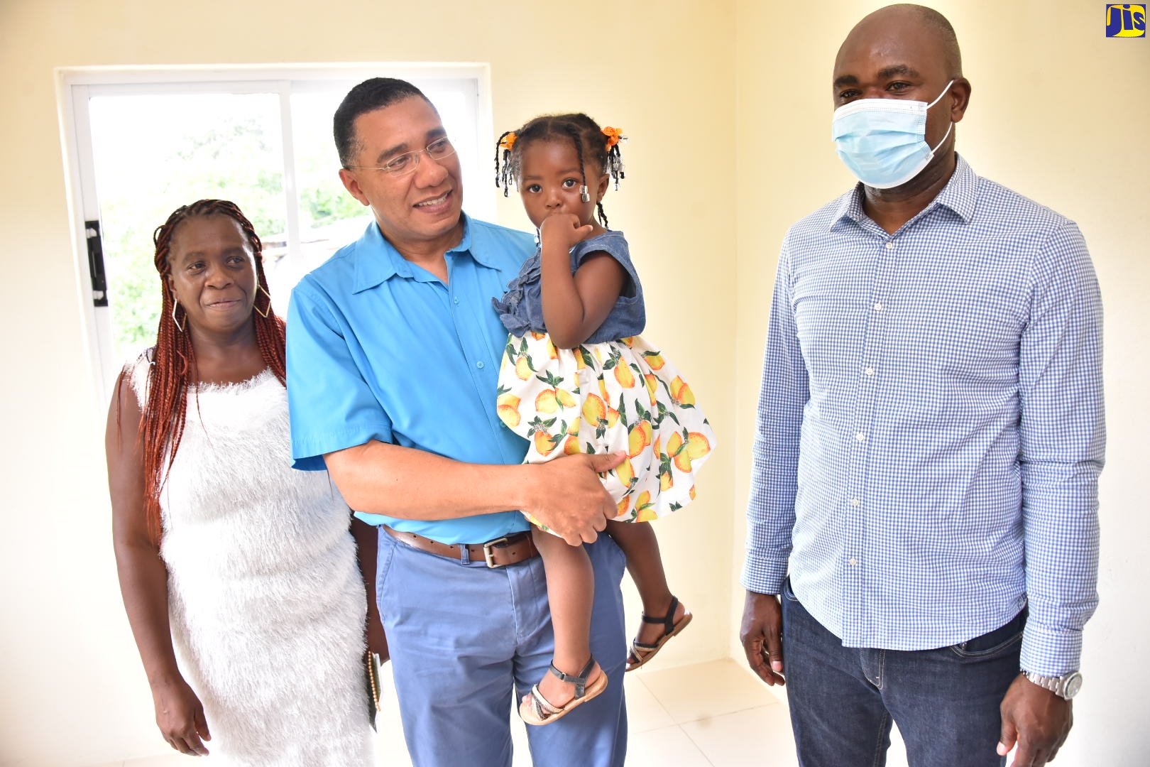Prime Minister, the Most Hon. Andrew Holness (centre), carries baby Zahara Walker, the granddaughter of New Social Housing Programme (NSHP) beneficiary Sophia Campbell (left), during a tour of Ms. Campbell’s new two-bedroom home in Cave Valley, St. Ann on Friday (August 19). Accompanying them is Minister of State in the Ministry of National Security, Hon. Zavia Mayne (right), who is also Member of Parliament for St. Ann Southwest.