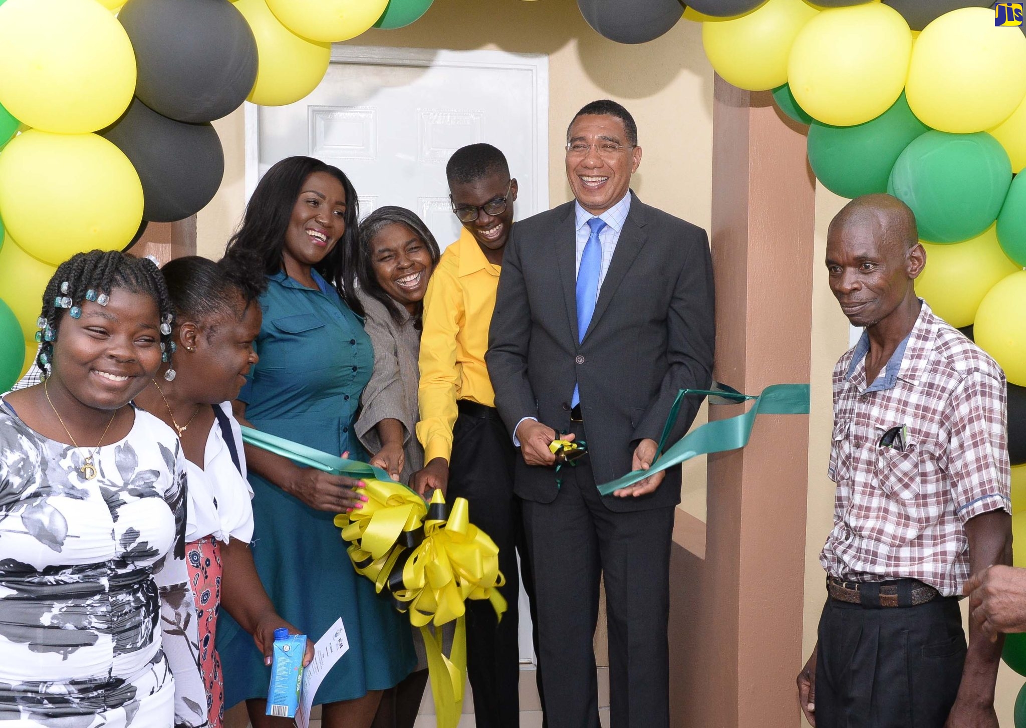 Prime Minister, the Most Hon. Andrew Holness (second right), cuts the ribbon to celebrate the official handover a new three-bedroom home to Delano Tucker (third right) and his family in Guy’s Hill, St. Catherine, on Wednesday (August 11). The unit was built under the New Social Housing Programme (NSHP). Joining in the occasion (from left) are daughter, Denisha Tucker; mother, Nattris Tucker; Member of Parliament for St. Catherine Northeast, Kerensia Morrison; Chairperson, Oversight Committee for NSHP, Judith Robb Walters, and father, Desmond Tucker.