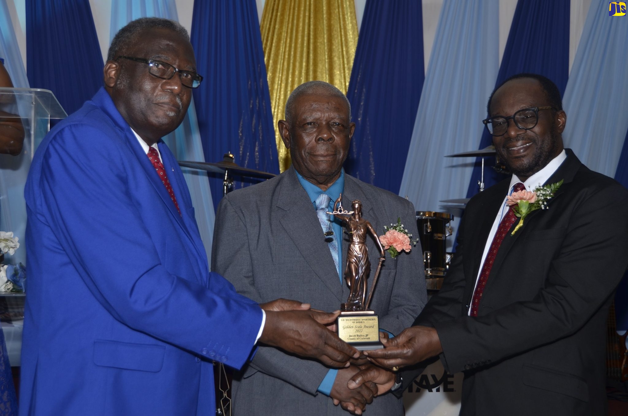 Custos of St. James, Bishop Conrad Pitkin (left), and President of the Lay Magistrates’ Association of Jamaica (LMAJ), Dr. Lynden Rose (right), present the Golden Scale Award 2022 for the County of Cornwall to Justice of the Peace from St. Elizabeth, Jacob Bailey. Occasion was the entity’s 27th Golden Scale Awards Banquet at Hotel Grand A View in Montego Bay on Saturday, August 20.