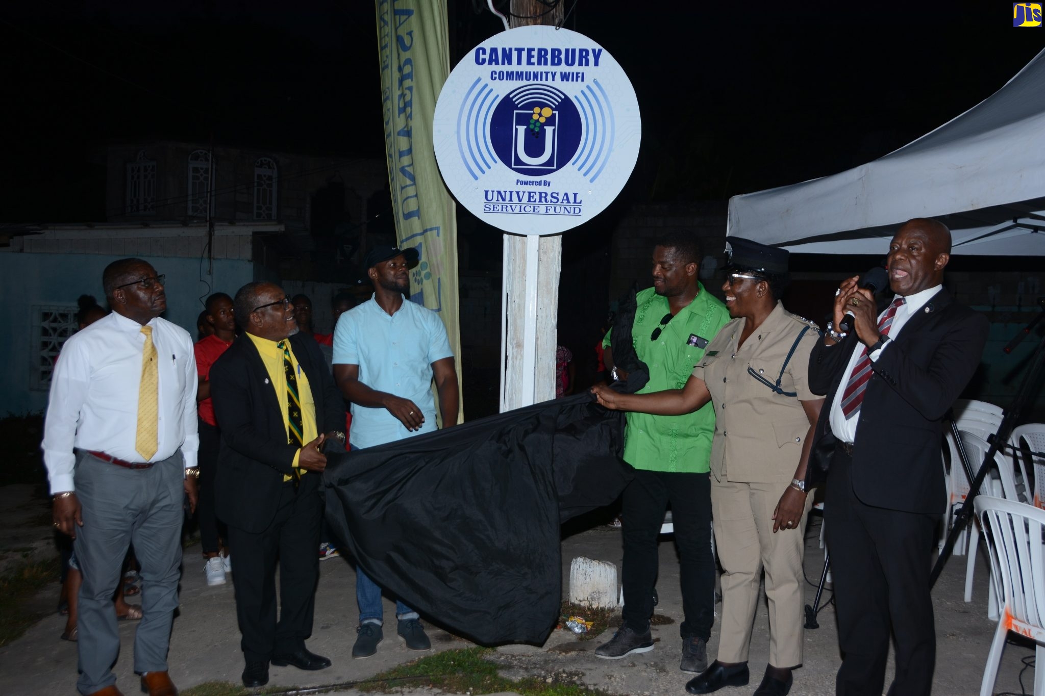 Chief Executive Officer of the Universal Service Fund, Daniel Dawes (right), is joined by (from left) Parish Manager for the St. James Health Department, Lennox Wallace; Pastor of the Redemption Chapel in Canterbury, Lascelles Thomas; Deputy Mayor of Montego Bay, Councillor Richard Vernon; St James Central Member of Parliament (MP), Heroy Clarke; and Deputy Superintendent of Police (DSP), St. James, Angela McIntosh-Gayle, in the unveiling of the sign for the Canterbury free, public Wi-Fi hotspot, in  St. James, on Monday, August 8.
