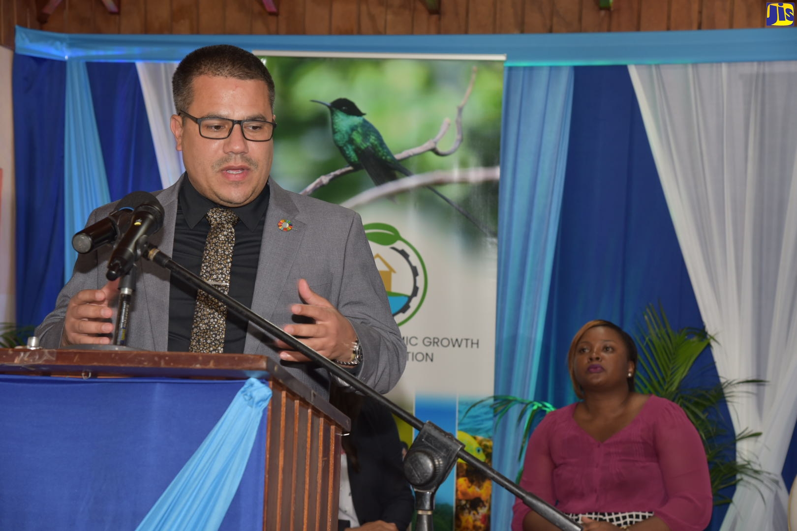 Minister without Portfolio in the Ministry of Economic Growth and Job Creation, Senator the Hon. Matthew Samuda (left), speaks on the management of plastics and the environment, during a Plastics Forum, held virtually on Tuesday, August 30.  Seated is  Head of the Technical Regulations Unit in the Bureau of Standards Jamaica, Phillipa O’Conner Bennett.