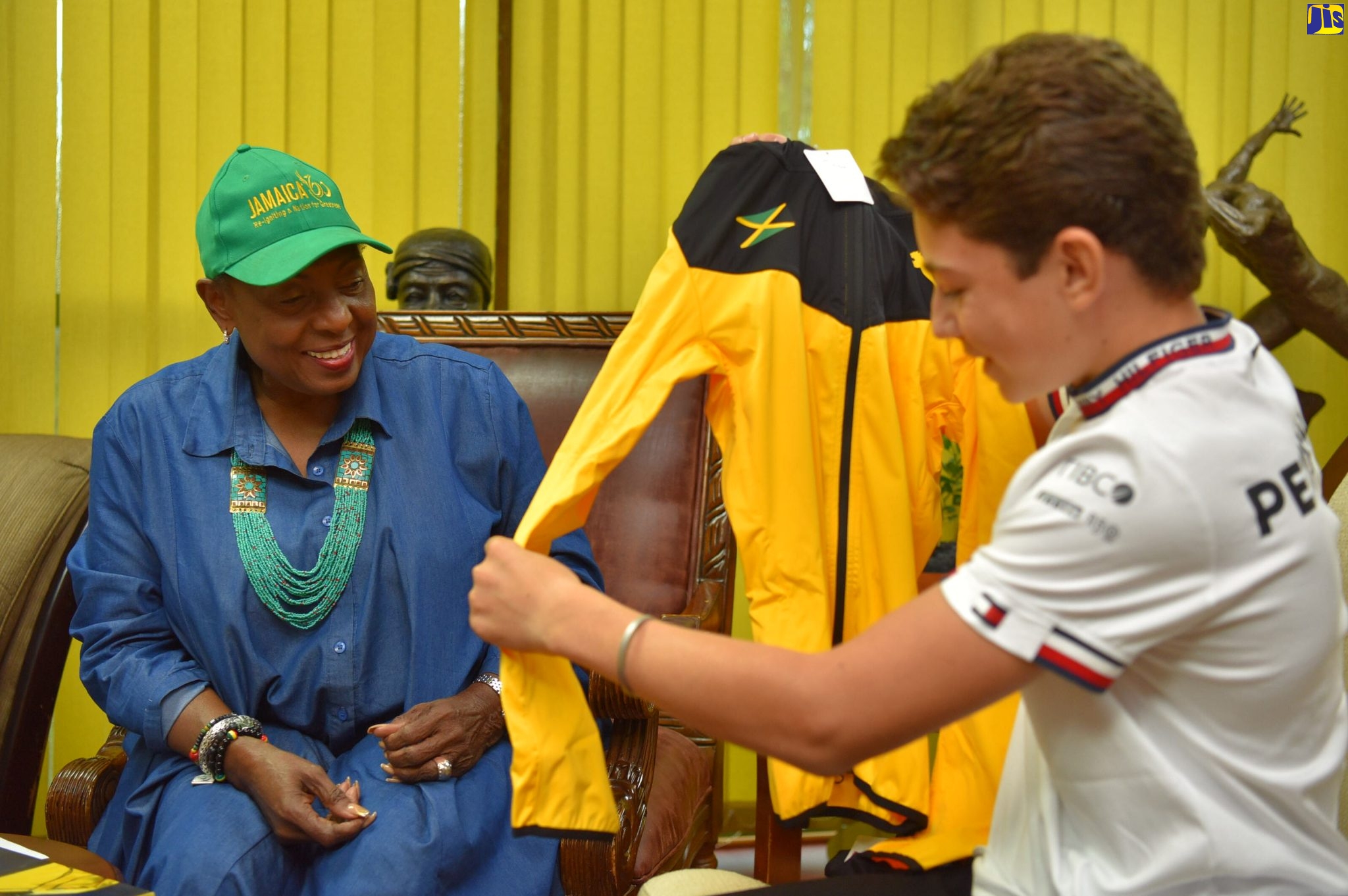 Culture, Gender, Entertainment and Sport Minister, Hon. Oliva Grange (left) presents karting star Alex Powell with a ‘Jamaica 60’ memorabilia. Minister Grange met with Powell on August 19 at the Ministry’s New Kingston offices.