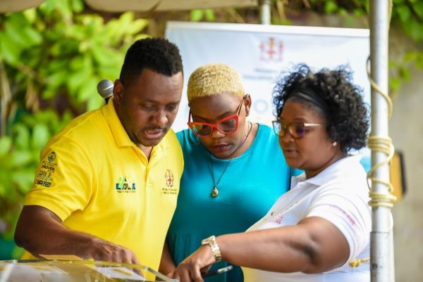 Camp Coordinator and Youth Empowerment Officer for St. James, Damian Green (left), points out something of interest in a document to Youth Empowerment Officer for Hanover, Haley Collins-McFarlane (centre), and Chief Executive Officer of M-Lee HR Consulting Services, Marsha-Lee Morris.  Occasion was the closing ceremony for the Behaviour Modification Summer camp, hosted by the Youth and Adolescent Policy Division of the Ministry of Education and Youth (MOEY) in Montego Bay, St. James, recently.
