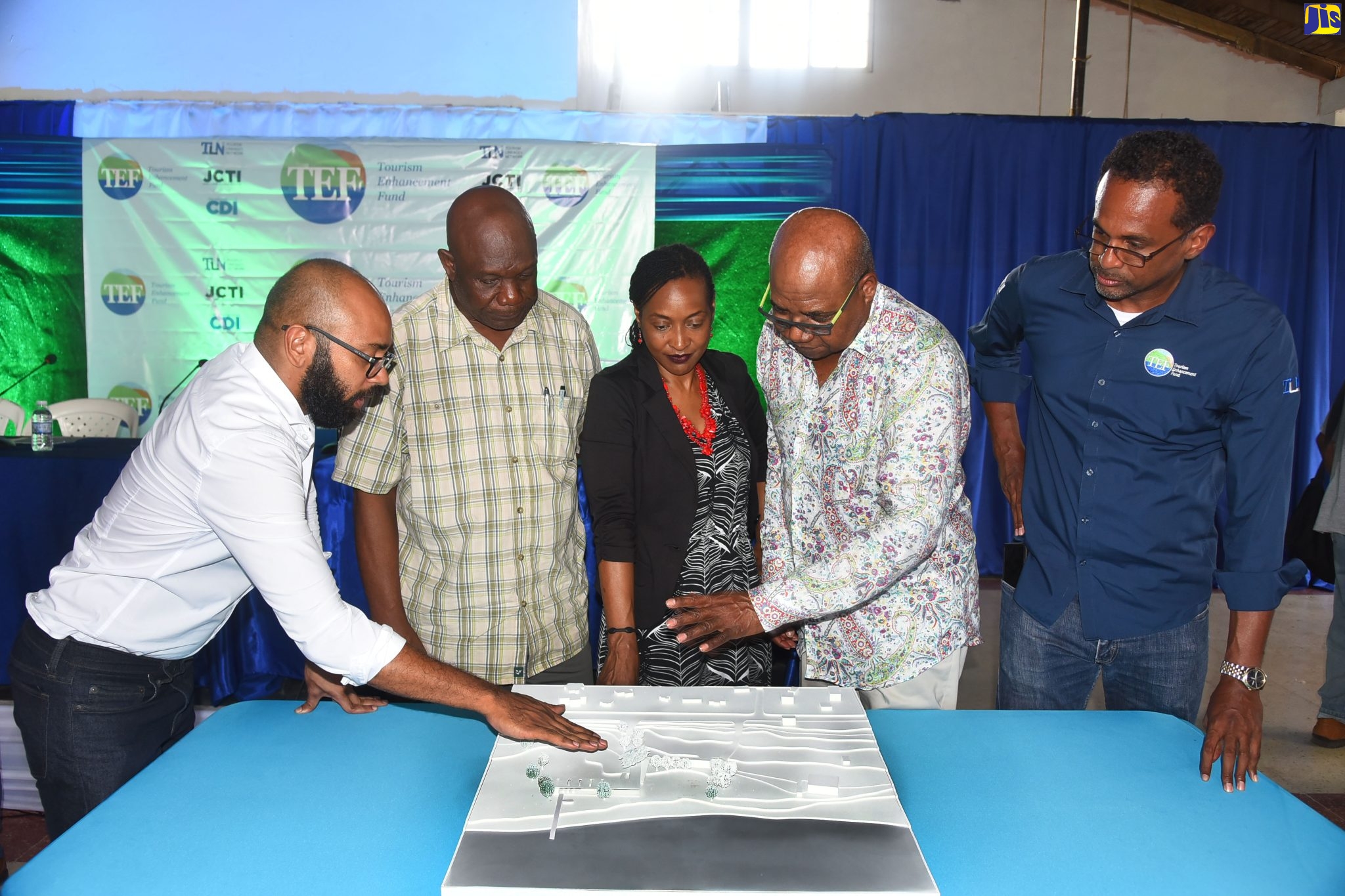Minister of Tourism, Hon. Edmund Bartlett (second right), looks at designs for the development of Priory Beach in St. Ann, being shown by architect at YAHSO Ltd., Andre Baugh (left), during a town hall meeting hosted by the Tourism Enhancement Fund (TEF) at the Alterry Beach Club in the parish, on August 28. Also looking at the designs (from second left) are: Mayor of St. Ann’s Bay, Councillor Sydney Stewart; Minister of State in the Ministry of Finance and Public Service and Member of Parliament for St. Ann Northeastern, Hon. Marsha Smith, and TEF Executive Director, Dr. Carey Wallace.
