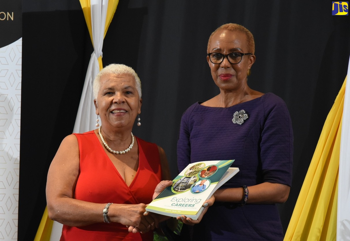 Minister of Education and Youth, Hon. Fayval Williams (right), receives a token from Immediate Past President, The Mico University College Alumni Association (MOSA), Dr Merrit Henry, during the opening ceremony of the MOSA’s centennial international education symposium at The Jamaica Pegasus hotel, on Wednesday (August 10).