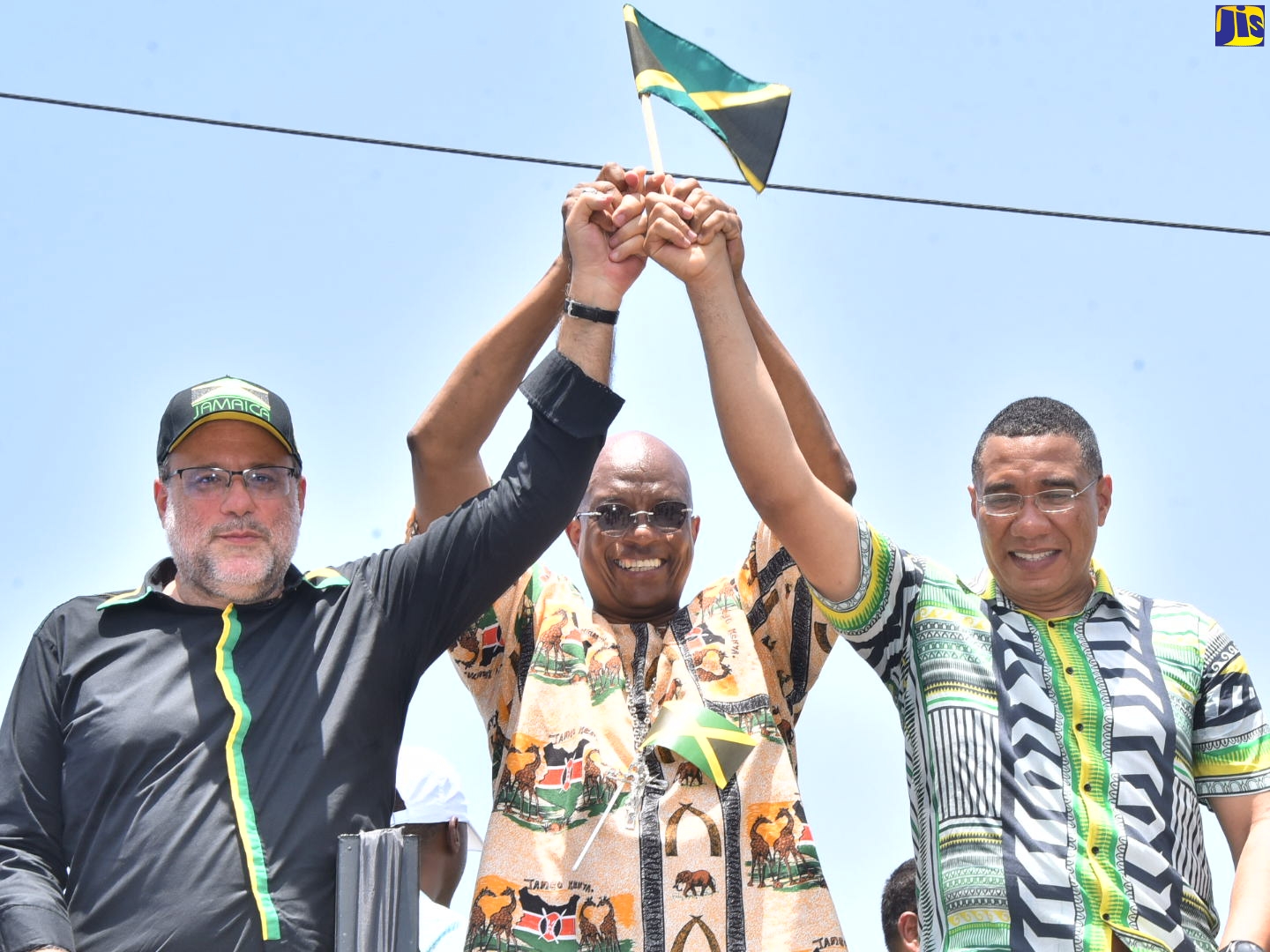 Prime Minister, the Most Hon. Andrew Holness (right), Archbishop of Kingston, Kenneth Richards (centre) and Opposition Leader, Mark Golding (left), raise hands together showcasing unity during the Jamaica 60 Float and Street Parade in Kingston on Monday (August 1).  