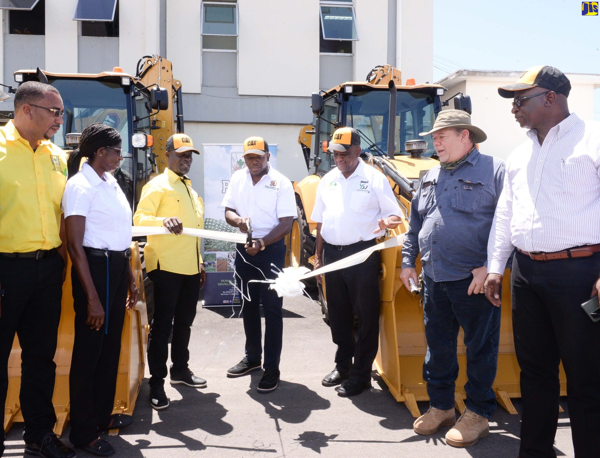 Minister of Agriculture and Fisheries, Hon. Pearnel Charles Jr. (centre) and State Minister, Hon. Franklin Witter (fifth left), participate in a ribbon-cutting exercise at the handover ceremony for two backhoes to the Rural Agricultural Development Authority (RADA) to support farming communities in St. Thomas and Westmoreland. Joining them are (from left) Parish Agricultural Managers, Westmoreland and St Thomas, Yuri Stephenson and Bevene Martin-Dickenson; Acting CEO, RADA, Winston Simpson; Vice Chairman, RADA Board of Directors, Richard King; and Chief Technical Director, Ministry of Agriculture and Fisheries, Orville Palmer.
