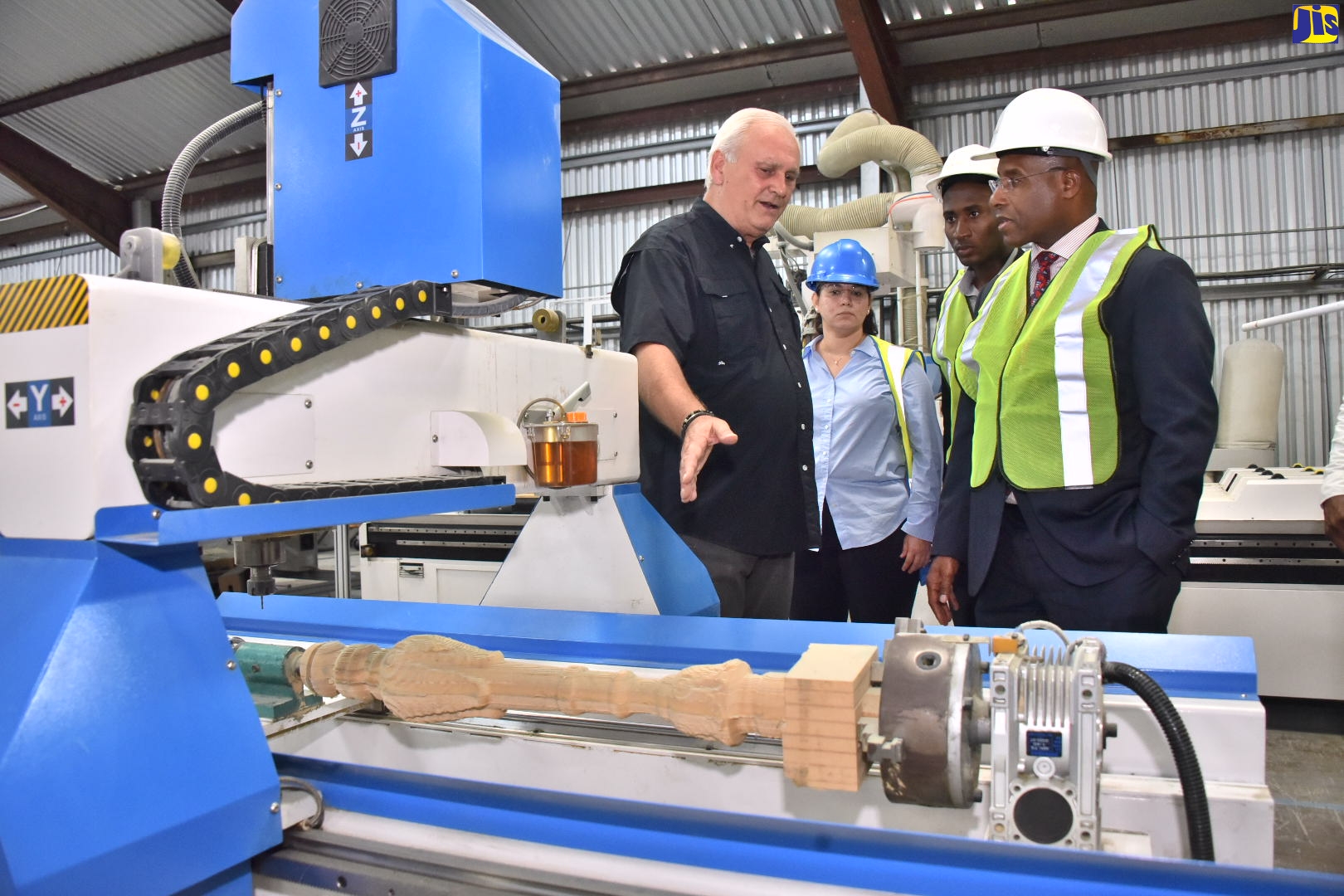 Minister of Industry, Investment and Commerce, Senator the Hon. Aubyn Hill (right), listens as Chief Executive Officer of Kingston Furniture, Tony Breslin (left), explains the functions of a machine that is used to manufacture furniture. Looking on are (from left) Sales Associate, Kingston Furniture, Victoria Thwaites and Advisor to the Minister, Dimitri South. The Minister toured the facility on Tuesday, September 6. 
