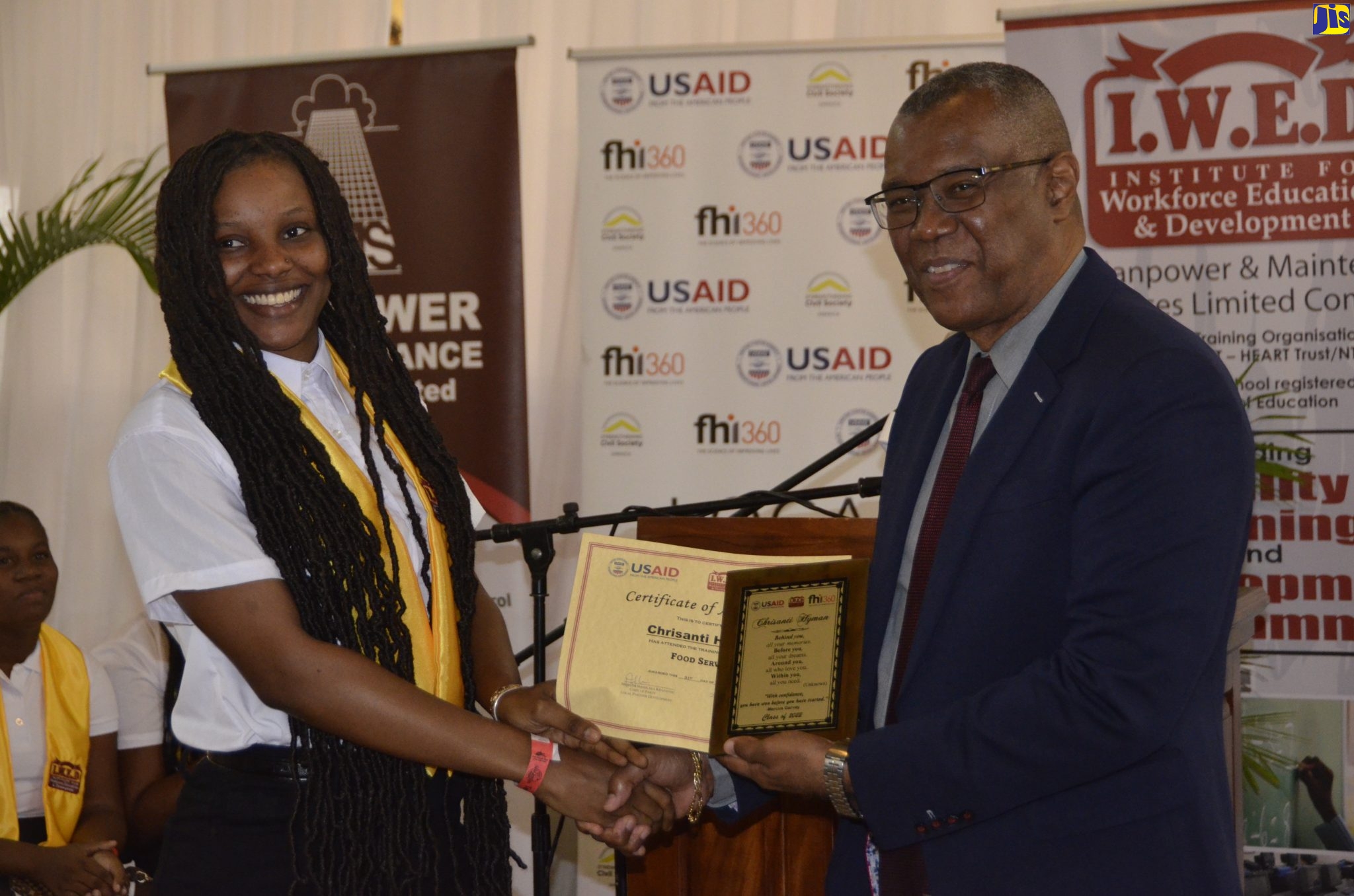 Councillor of the Montego Bay Northeast Division,  Senator Charles Sinclair (right), hands Institute for Workforce Education and Development (IWED) vocational and skills training programme graduate, Chrisanti Hyman, her Food Services certificate and plaque. Occasion was the graduation ceremony for the programme, held on Wednesday (August 31), at the Sea Garden Resort in St. James. Senator Charles represented Minister of National Security, Hon. Dr. Horace Chang, at the event.  IWED, a member of the Manpower and Maintenance Services (MMS) Limited Group, was funded by the United States Agency for International Development (USAID) through Local Partner Development FHI360a and MMS. Some 28 at-risk youth, ages 17 to 29, from the communities of Canterbury, Rose Heights and Flanker in St. James, received certificates in food services and waitering. The programme was implemented over a six-month period, March to August. 
