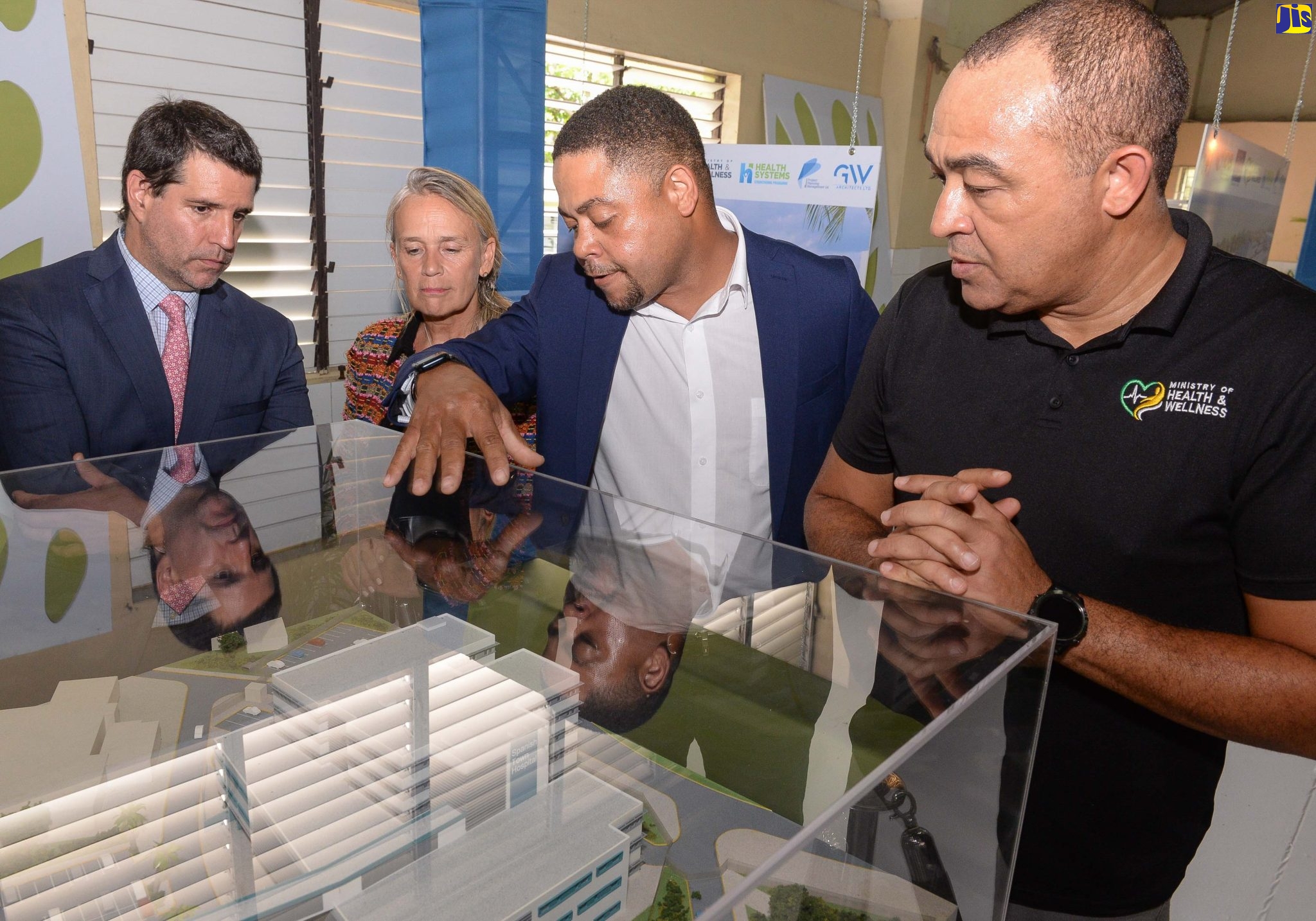 Minister of Health and Wellness, Dr the Hon. Christopher Tufton (right), listens as architect, Garfield Wood (second right), highlights features on the replica of the new main building to be constructed at the Spanish Town Hospital in St. Catherine. Looking on (from left) are Acting Inter-American Development Bank (IDB) Country Representative for Jamaica, Lorenzo Escondeur, and Head of the European Union Delegation to Jamaica, Belize, The Bahamas, and the Turks and Caicos Islands, Ambassador Marianne van Steen. They were attending a recent Open House and Exhibition ceremony for the rehabilitation of Public Health Facilities in St. Catherine, at the Open Bible Church in Twickenham Park, St. Catherine.
