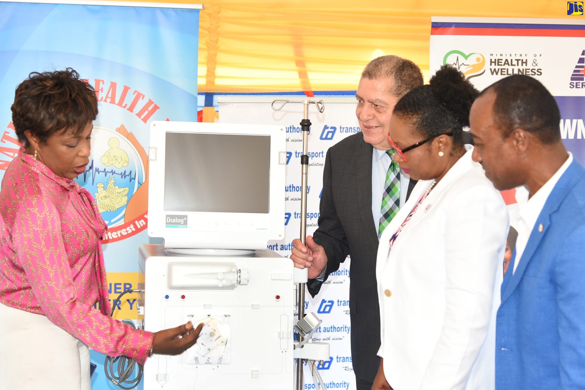 Minister of Transport and Mining, Hon. Audley Shaw (second left), looks on as Senior Medical Officer, Spanish Town Hospital, Dr. Jacqueline Wright James
(left), highlights the features of one of three dialysis machines donated to the St. Catherine-based institution on Wednesday (September 14), by the Transport Authority and the National Health Fund (NHF). The hospital’s Chief Executive Officer, Jacqueline Ellis (second right), and Transport Authority Managing Director, Willard Hylton, also observe.