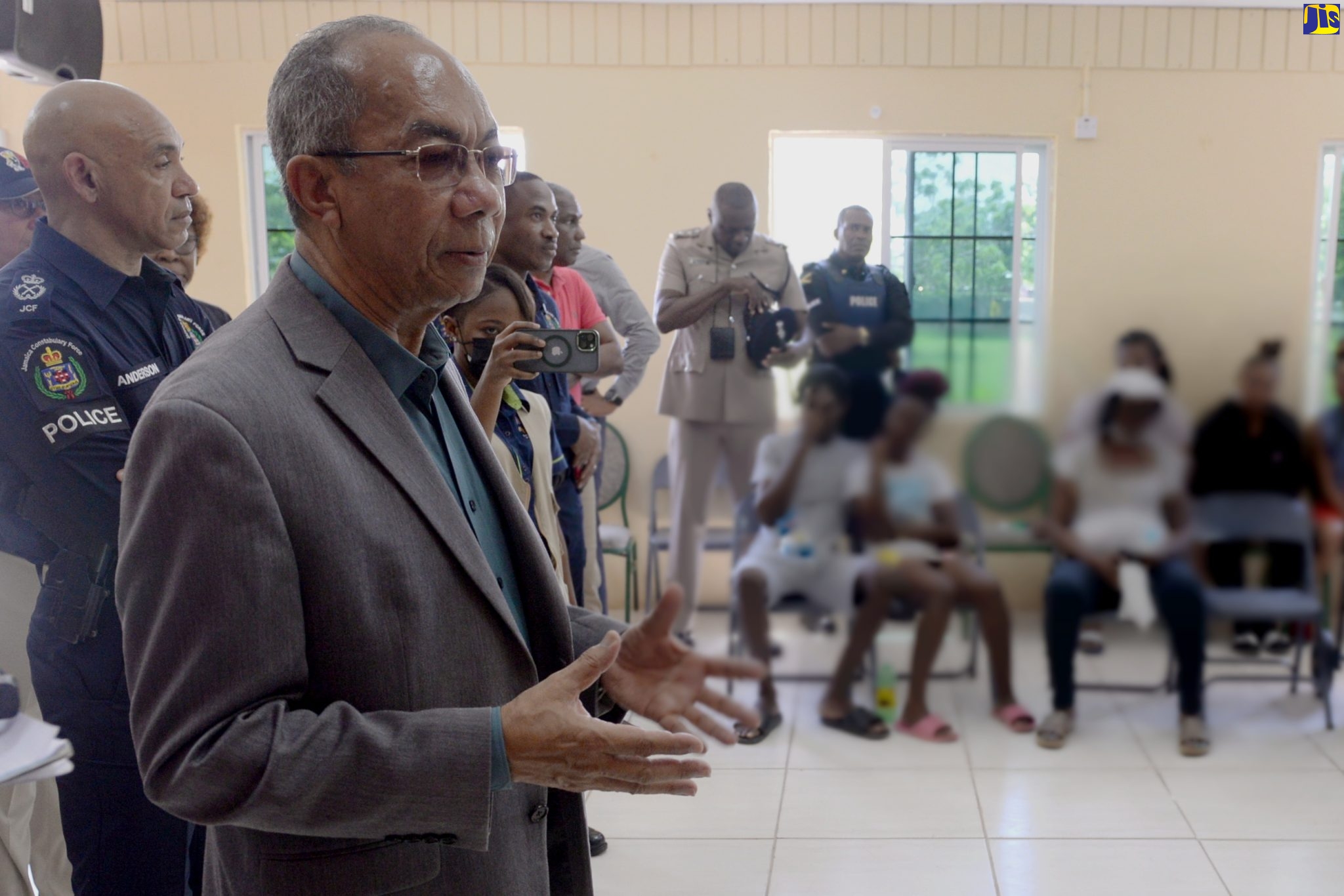 Deputy Prime Minister and Minister of National Security, Hon. Dr. Horace Chang (second left), addresses community members in Spring Village, St. Catherine, on Wednesday (September 21), while on a visit to the area where he and members of the Police High Command met with grieving residents, following Sunday’s (September 18) attack by gunmen on patrons attending a football match. At left is Police Commissioner, Major General Antony Anderson.