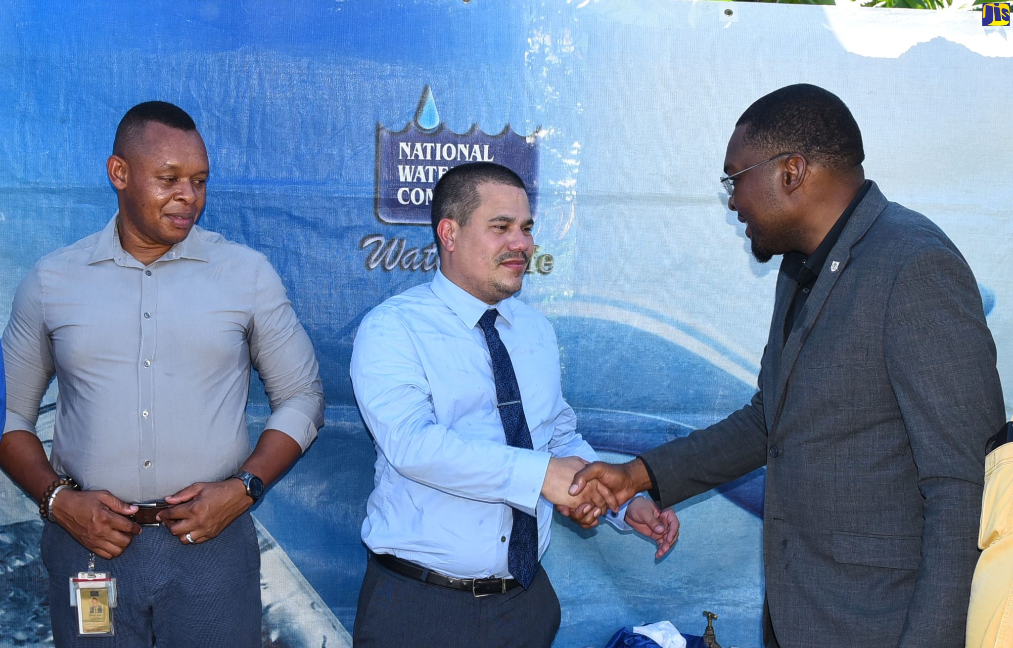 Minister without portfolio in the Ministry of Economic Growth and Job Creation, Senator the Hon. Matthew Samuda (centre), greets Minister without Portfolio with responsibility for Information and Member of Parliament for Clarendon North Central, Hon. Robert Morgan, during the commissioning of the upgraded water system in Wood Hall, Clarendon, on September 8. Looking on is National Water Commission (NWC) Vice President for Operations, Kevin Kerr.