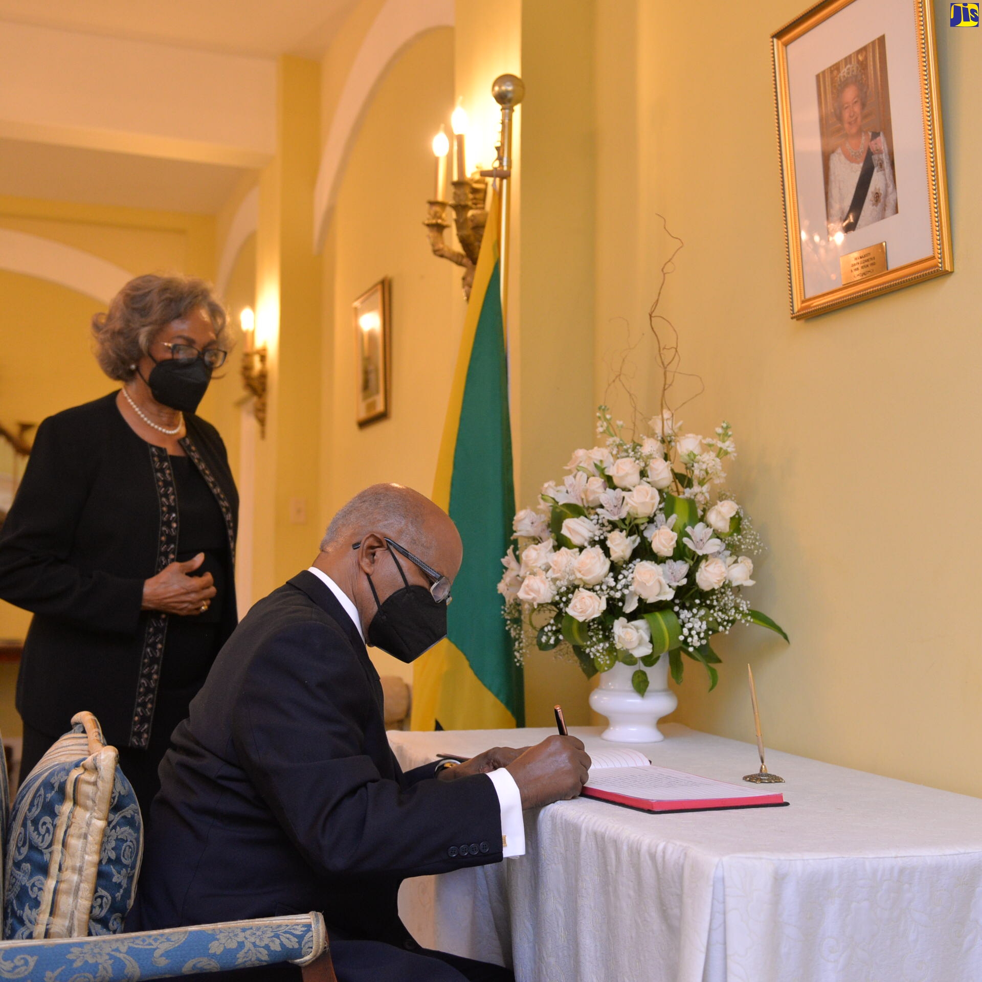 Former Governor-General, His Excellency the Most Hon. Professor Sir Kenneth Hall, signs the Condolence Book which has been opened at King’s House for Great Britain’s late Monarch, Her Majesty, The Queen. Looking on is the Most Hon. Lady Hall who, along with Sir Kenneth, signed the Book on Sunday (September 11).

