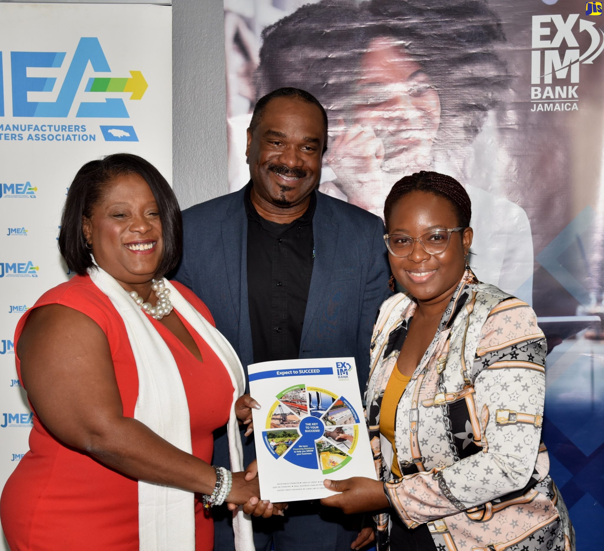 Managing Director, National Export-Import Bank of Jamaica (EXIM Bank), Lisa Bell (left), and Chief Executive Officer, Jamaica Manufacturers and Exporters Association (JMEA), Kamesha Blake, display a folder with the partnership agreement signed by both organisations for the ‘EXIM Ecommerce Funder’, to assist small and medium-sized enterprises, on Friday (September 16), at the Bank’s headquarters in St. Andrew. Observing is Business Development Consultant, EXIM Bank, Winston Lawson.