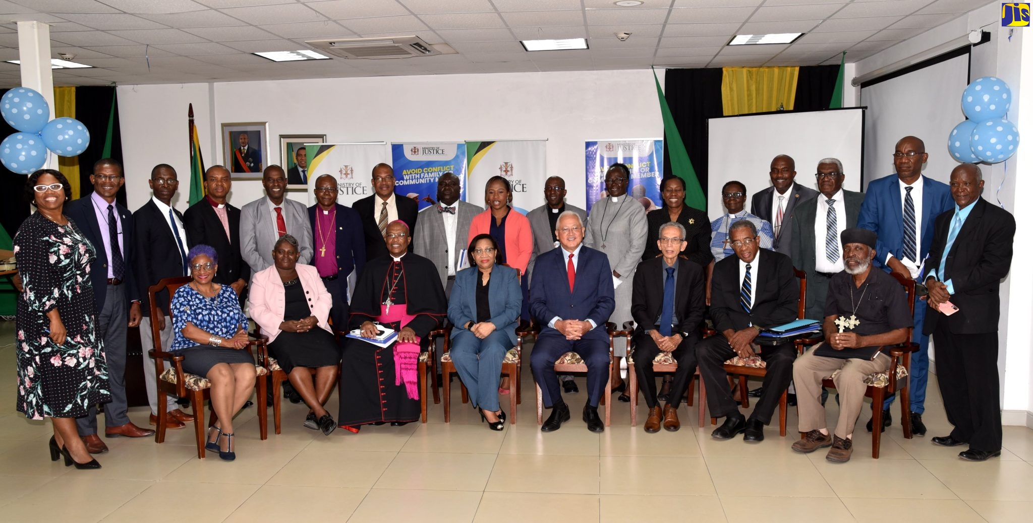 Justice Minister, Hon. Delroy Chuck (fourth right. seated); Permanent Secretary, Grace Ann Stewart McFarlane (fifth right, seated); and National Restorative Justice Coordinator, Andriene Lindsay Williams (ninth left, standing) are flanked by members of the local faith-based community following Tuesday’s restorative justice programme partnership agreement signing ceremony at the Ministry’s office in Kingston.